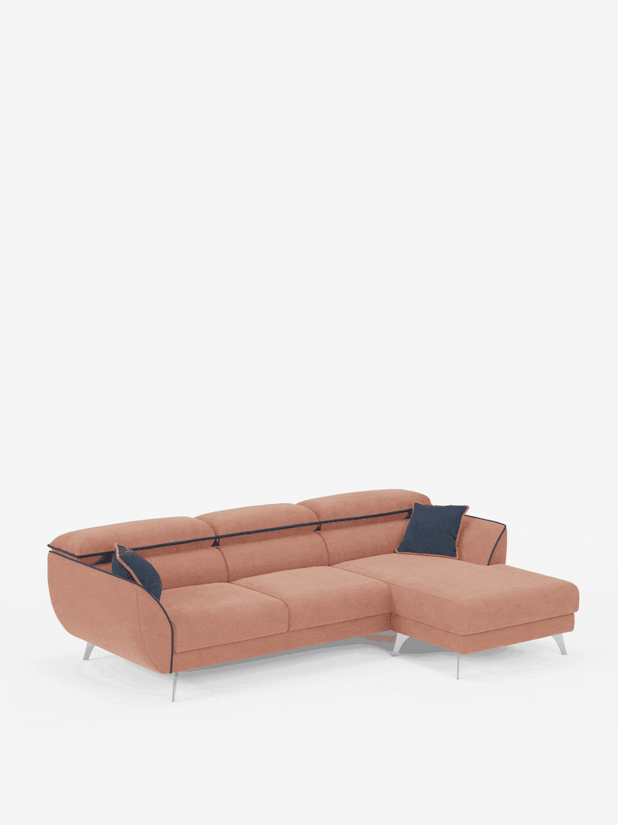 Il divano angolare bicolore Michelangelo con penisola e sedute estensibili di Divani.Store, in stile contemporaneo, è presentato in una tenue tonalità corallo con eleganti gambe in metallo. È dotato di una chaise longue sul lato destro, poggiatesta reclinabili regolabili in tessuto smacchiabile T23 per un comfort personalizzabile e due cuscini decorativi blu navy scuro disposti sulla destra su uno sfondo bianco brillante.