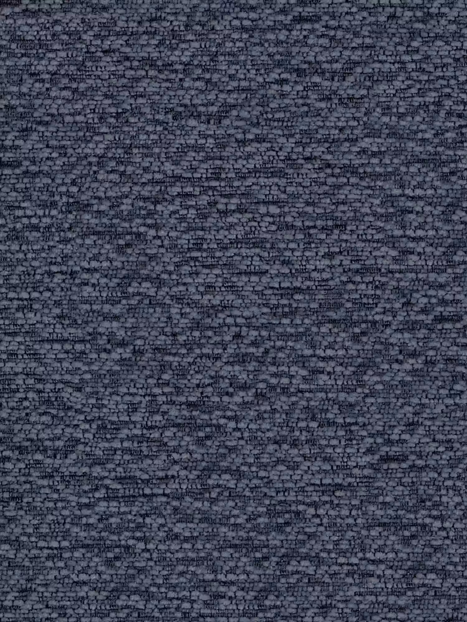 Un primo piano di una parete in pietra grigio scuro dalla superficie ruvida crea uno sfondo di grande effetto per la sedia “Alba”, imbottita in tessuto effetto cotone certificato OEKO-TEX® con base in metallo nero di Divani.Store, il cui look elegante e moderno contrasta con l’arredamento rustico.