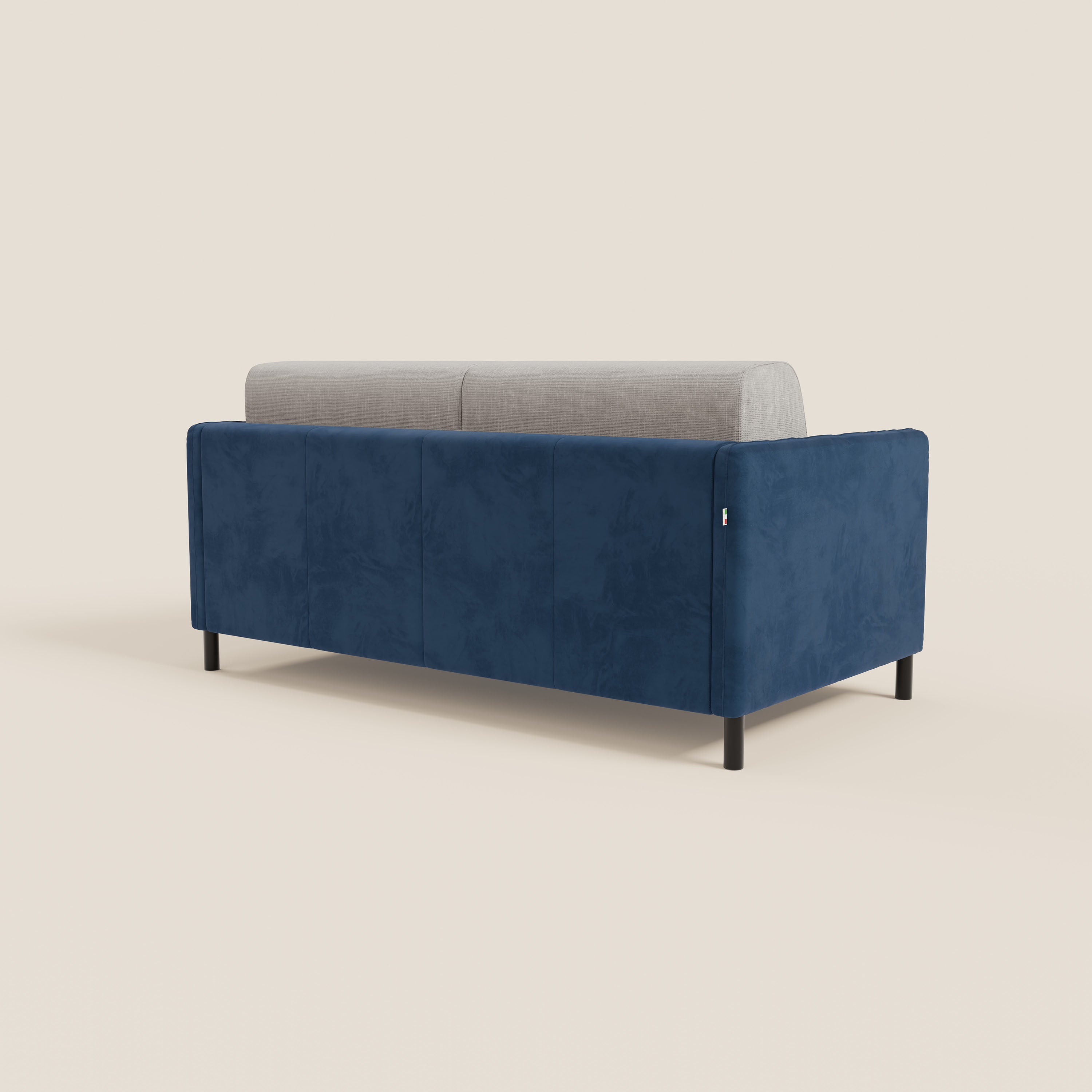 Il divano letto Narciso di Divani.Store è caratterizzato da un design bicolore con microfibra antimacchia di colore blu intenso, cuscini in tessuto impermeabile T06 grigio chiaro e gambe nere. Visto di spalle su uno sfondo beige, evidenzia il suo stile minimalista.