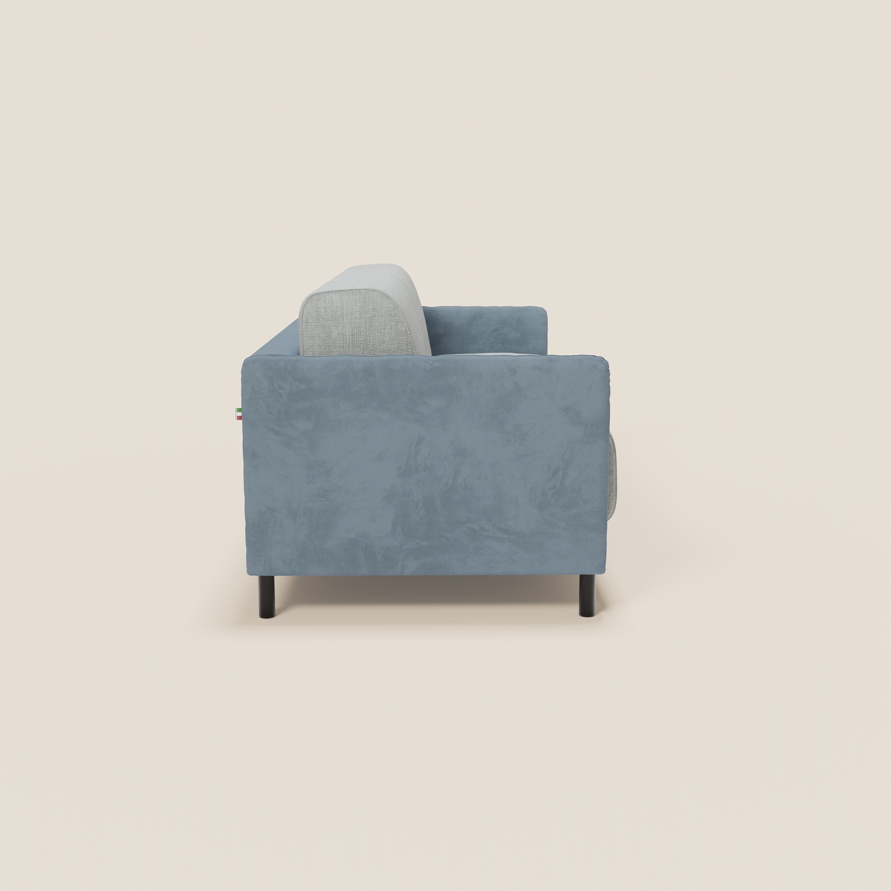 Vista laterale del divano letto Narciso di Divani.Store, con materasso bicolore H18 cm, struttura in microfibra smacchiabile, tessuto impermeabile T06 carta da zucchero-ghiaccio, gambe nere, meccanismo a ribalta e targhetta con bandiera italiana su sfondo bianco sporco.