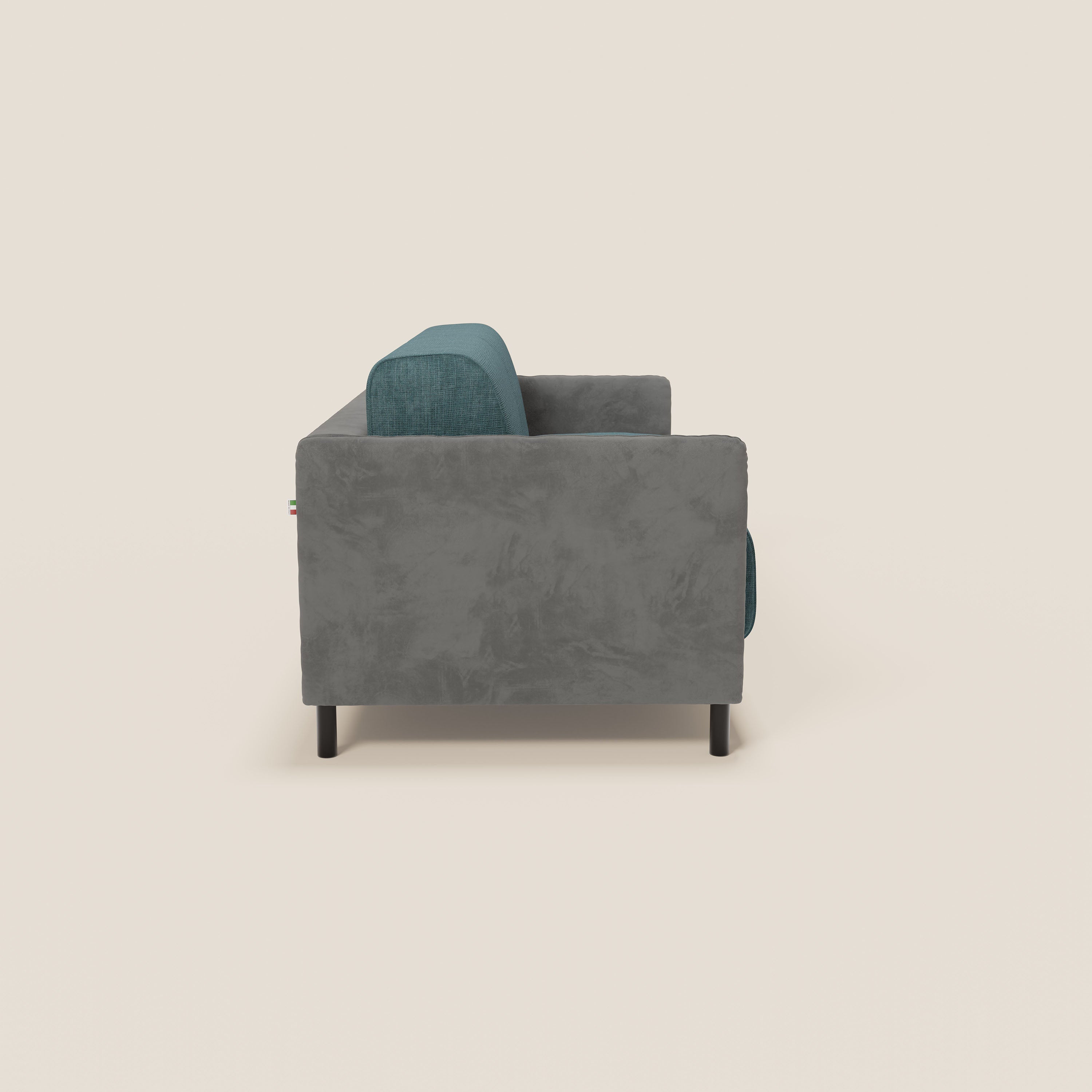 Vista laterale del divano letto Narciso di Divani.Store: design bicolore con struttura in microfibra antimacchia, rivestimento impermeabile grigio scuro e verde acqua, gambe cilindriche nere e materasso H18 cm incluso. In foto, su uno sfondo beige chiaro.