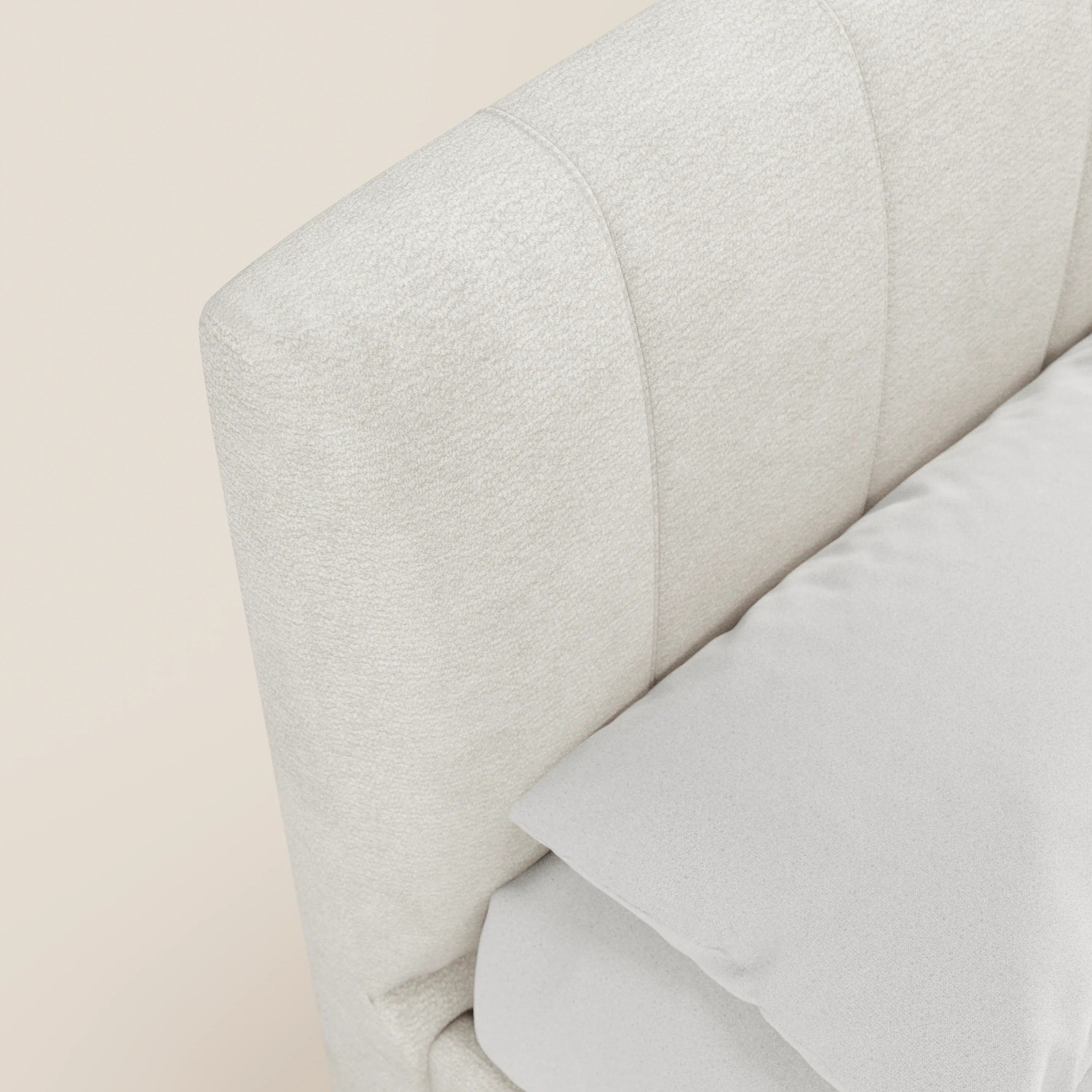 Primo piano del letto imbottito con contenitore ONYX di Letti.store, caratterizzato da una testiera in tessuto beige chiaro certificato Oeko-Tex® con cuciture verticali e da una coperta grigio chiaro che ne esalta la morbida consistenza e lo stile minimalista.