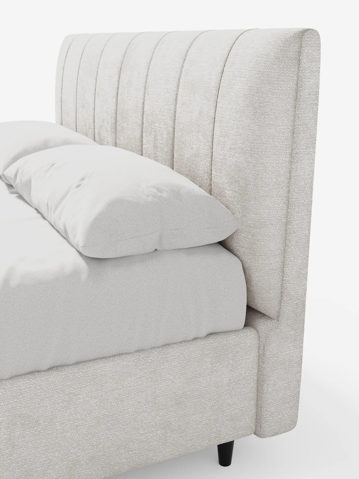 Vista laterale di un letto imbottito ONYX con contenitore e testiera verticale in tessuto certificato Oeko-Tex®, caratterizzato da un'alta testiera imbottita beige, due morbidi cuscini e un materasso poggiato su corte gambe cilindriche scure.