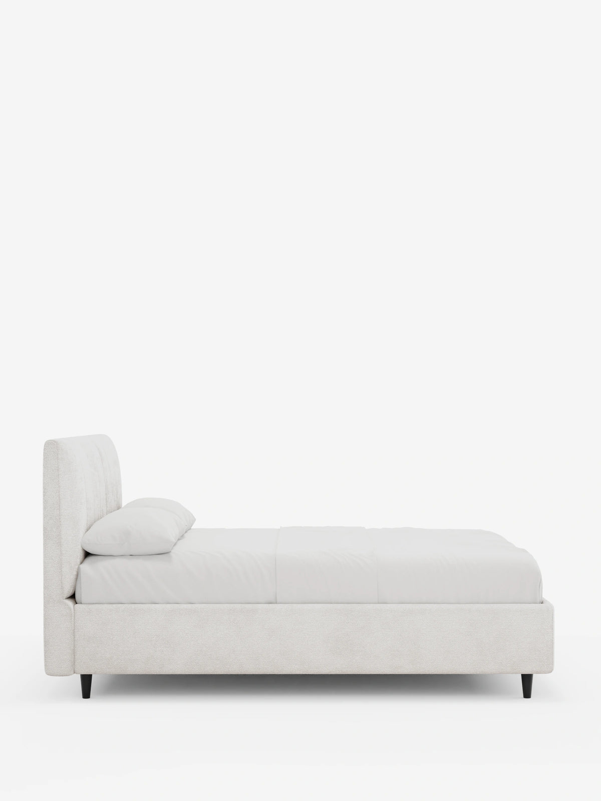 Vista laterale di un letto imbottito ONYX con contenitore e testiera verticale in tessuto certificato Oeko-Tex® color beige chiaro, caratterizzato da una testiera alta trapuntata, biancheria da letto candida e piccole gambe affusolate nere su sfondo bianco.