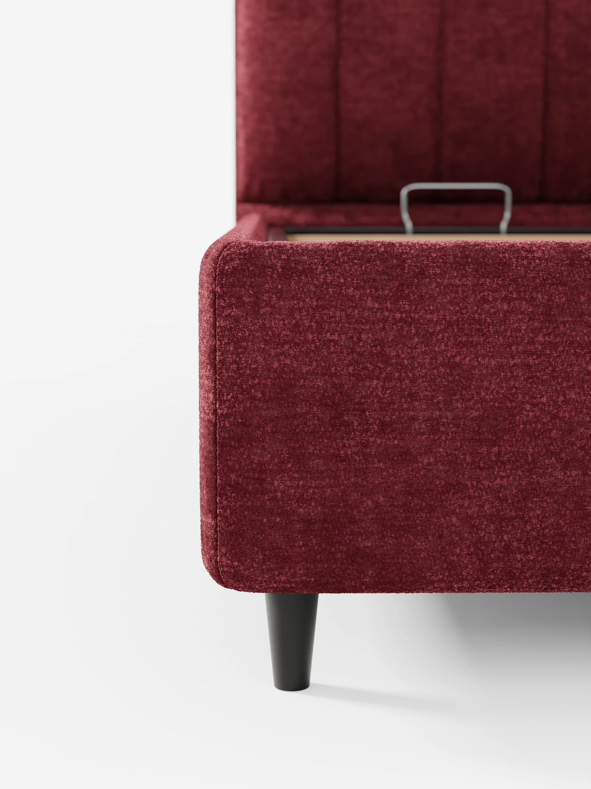 Un primo piano del letto imbottito ONYX con contenitore e testiera verticale in tessuto certificato Oeko-Tex® color bordeaux, caratterizzato da una testiera alta con cuciture verticali, una base contenitore con materasso rialzato e gambe scure affusolate.