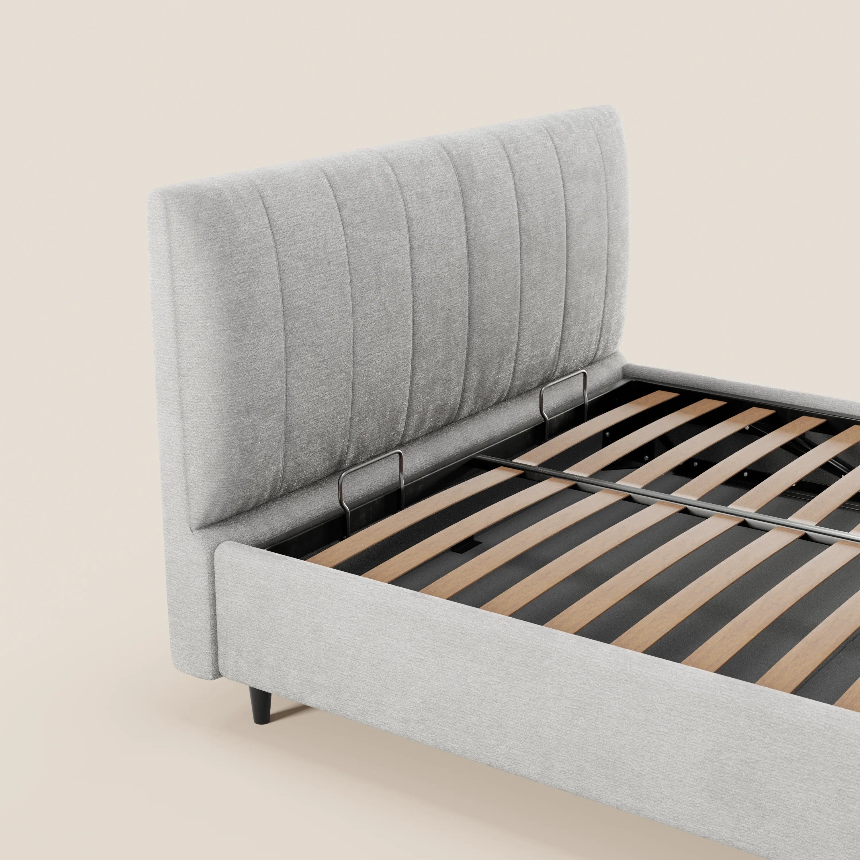 Il letto imbottito ONYX di Letti.store presenta una testiera alta con canalature verticali in tessuto grigio chiaro certificato Oeko-Tex®, con doghe in legno e supporti in metallo nero. Nell’immagine è raffigurato senza materasso né biancheria da letto, su uno sfondo beige a tinta unita.