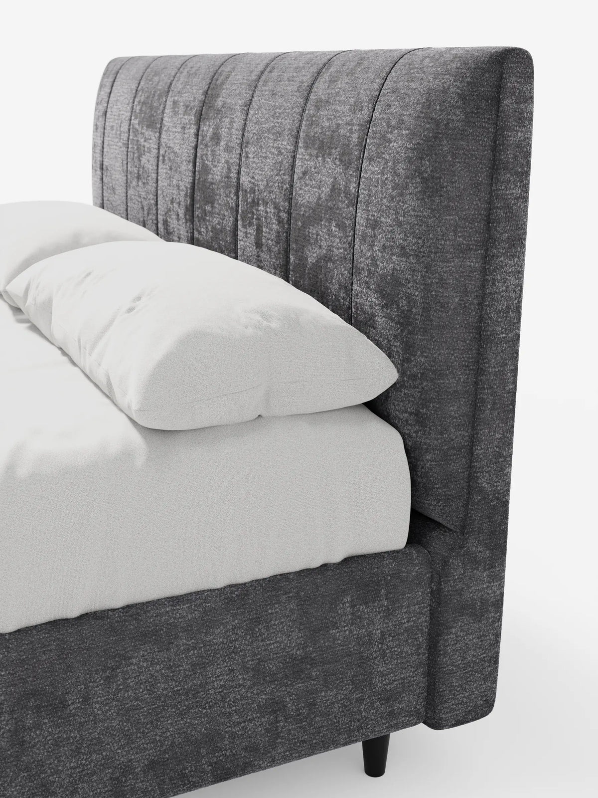Un letto imbottito ONYX grigio scuro con contenitore e testiera verticale in tessuto certificato Oeko-Tex®, caratterizzato da una testiera alta a pannelli verticali e da lenzuola bianche, su uno sfondo bianco a tinta unita.