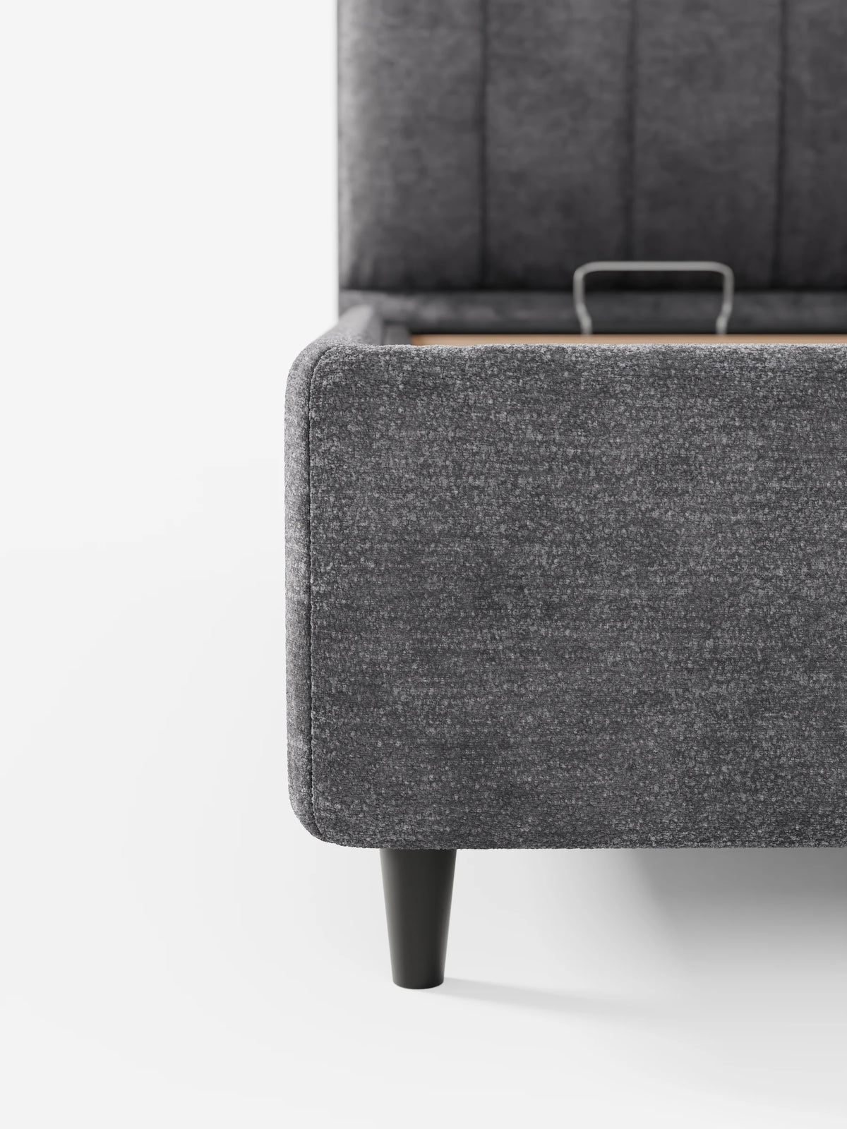 Il letto imbottito ONYX con contenitore e testiera verticale in tessuto certificato Oeko-Tex® è un letto contenitore grigio scuro con una testiera alta a pannelli verticali, poggiata su gambe nere affusolate, che spicca su uno sfondo bianco a tinta unita.