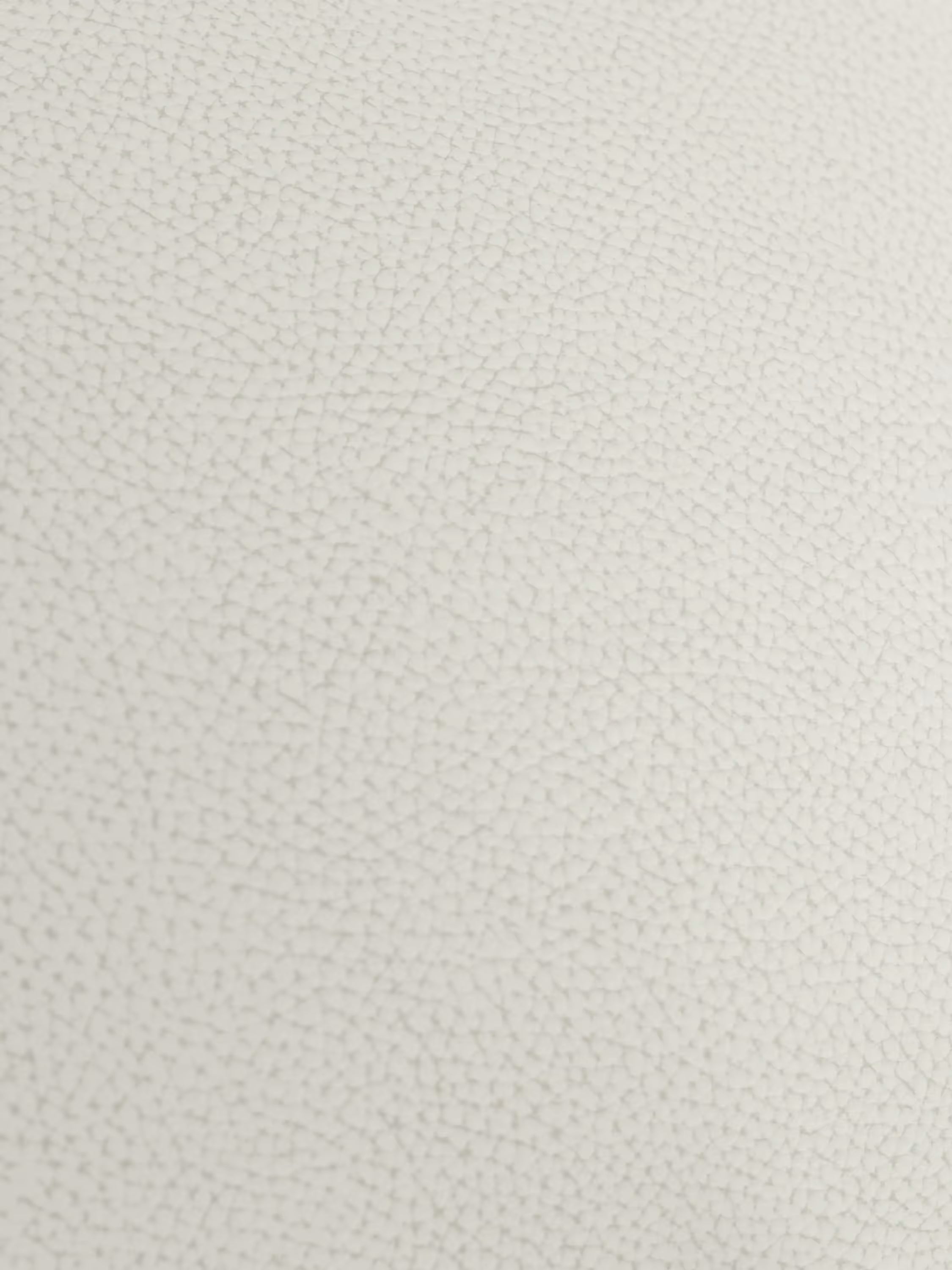 Primo piano della superficie bianca testurizzata del divano Chester 4 Posti 3 sedute in Vera Pelle – Chesterfield Capitonné Artigianale di Divani.Store, caratterizzata da un raffinato motivo di piccole crepe e linee interconnesse che formano una griglia sottile e irregolare. L’illuminazione uniforme mette in risalto la caratteristica trama della vera pelle tipica della lavorazione artigianale, senza ombre nette né variazioni di colore.