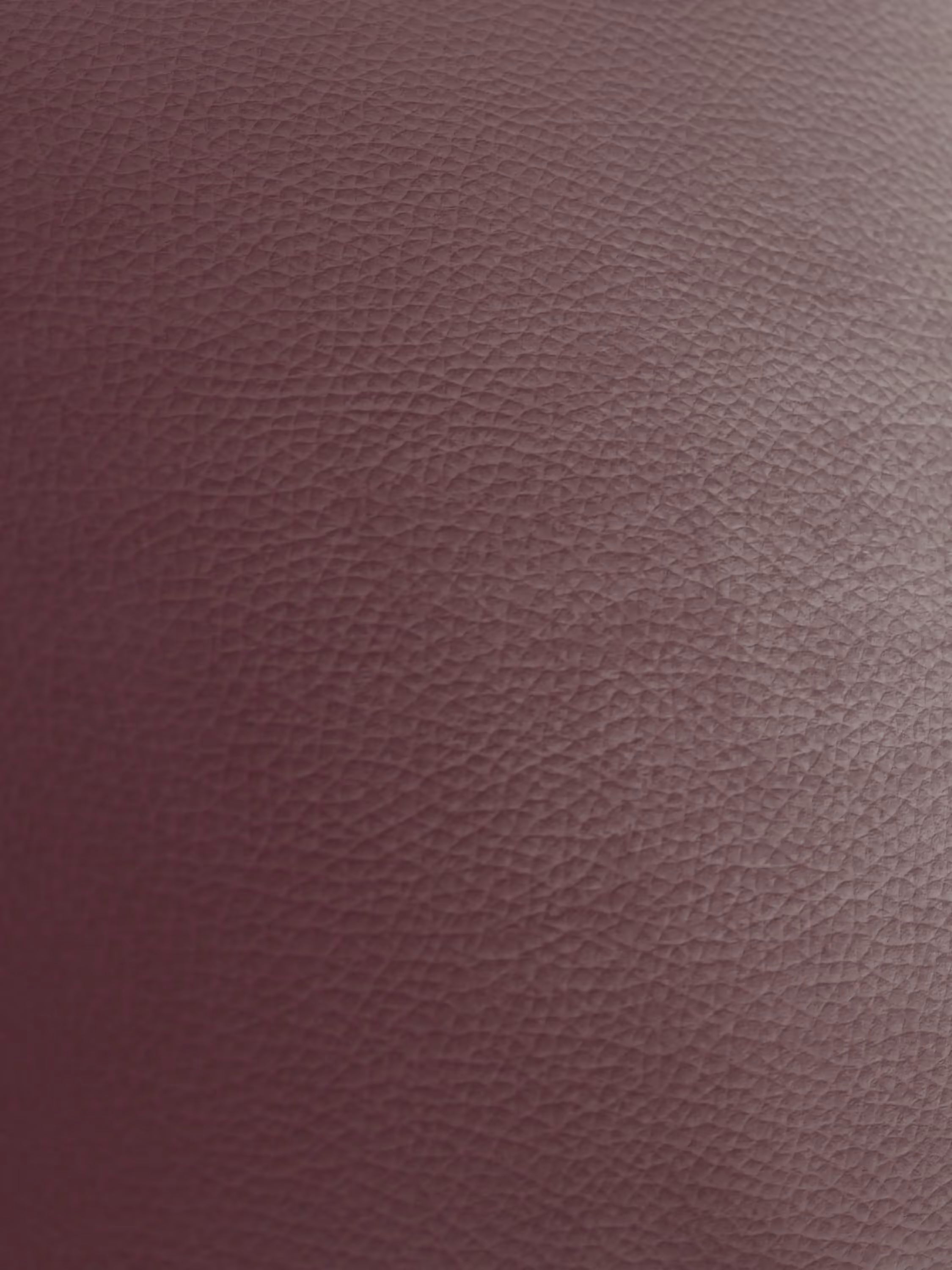 Primo piano della vera pelle marrone rossiccio con texture del modello Chester 4 Posti 3 sedute in Vera Pelle – Chesterfield Capitonné Artigianale di Divani.Store. L'immagine mostra un motivo dettagliato costituito da piccole granulosità in rilievo simili a ciottoli, con un'illuminazione che accentua la lussuosa trama della pelle — iconica dei classici modelli di divano Chesterfield — creando una lucentezza delicata e una profondità visiva. Nell'immagine non sono visibili altri oggetti o elementi.