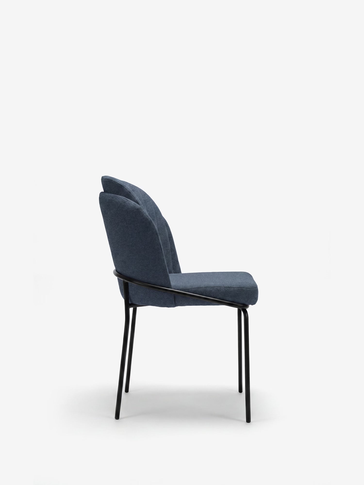 La sedia imbottita Plissè di Divani.Store è raffigurata di profilo su uno sfondo bianco; presenta una seduta in tessuto impermeabile blu, uno schienale plissettato e sottili gambe in metallo nero, per un look moderno e minimalista.