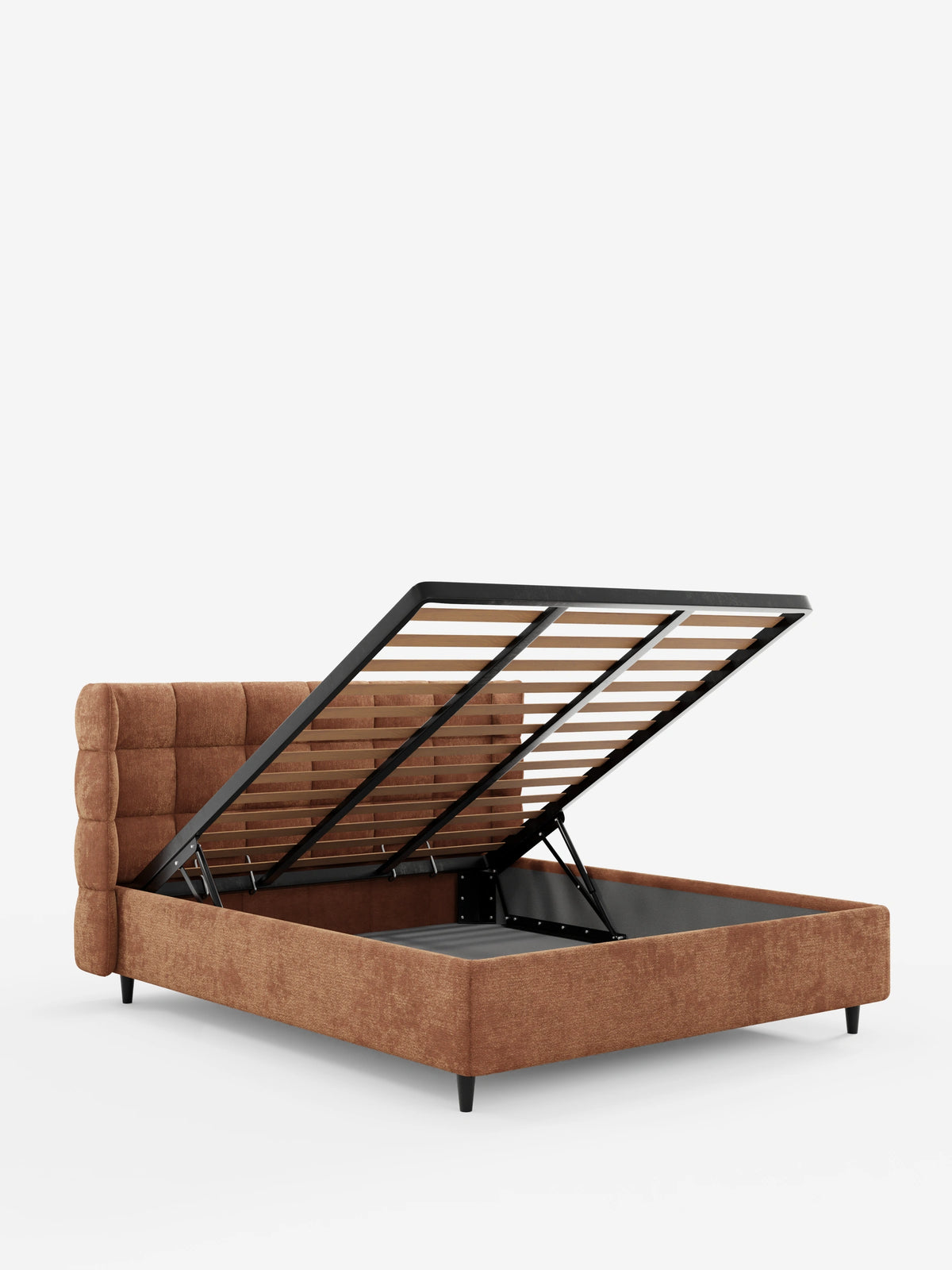 Un letto imbottito RAGNAR color ruggine, dotato di vano contenitore e testiera capitonné avvolgente, è collocato in un monolocale bianco con la rete a doghe sollevata per rivelare il vano contenitore.
