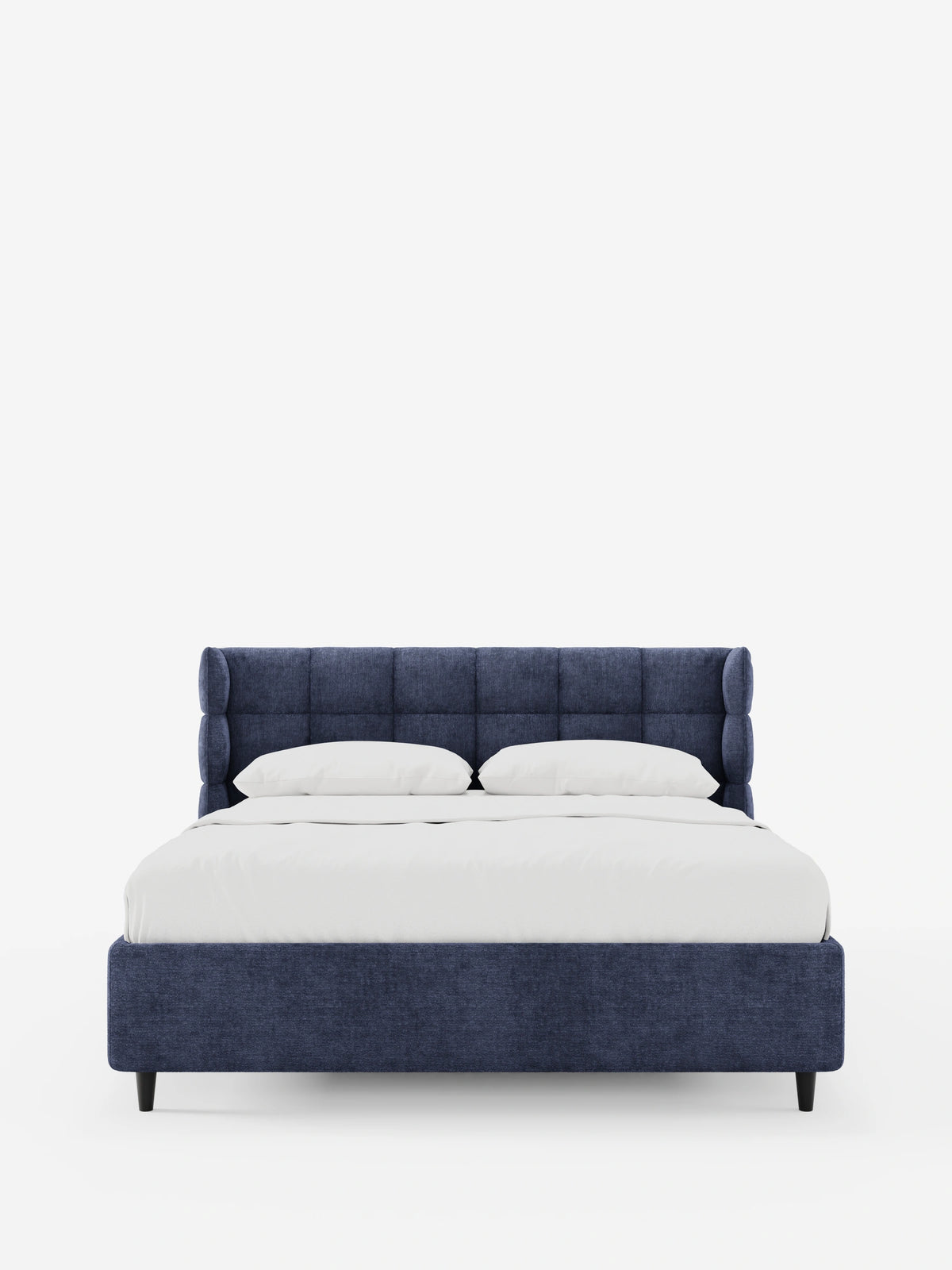 Un letto imbottito RAGNAR blu navy con contenitore e testiera capitonné avvolgente, caratterizzato da una testiera alta e capitonné e da gambe basse di colore scuro, rivestito con lenzuola bianche immacolate su uno sfondo bianco pulito.