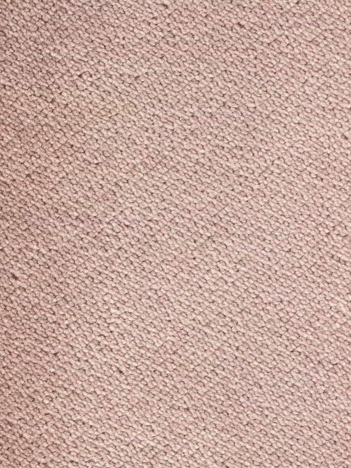 Un primo piano del tessuto vellutino rosa chiaro e testurizzato del divano letto Dalia a 2, 3 e 4 posti con materasso H18 di Divani.Store mostra un motivo a trama fitta composto da piccoli fili in rilievo, perfetto per un divano in stile scandinavo moderno. La superficie appare morbida e uniforme, con sottili variazioni nella trama e nella tonalità di colore caratteristiche del rivestimento smacchiabile T30.