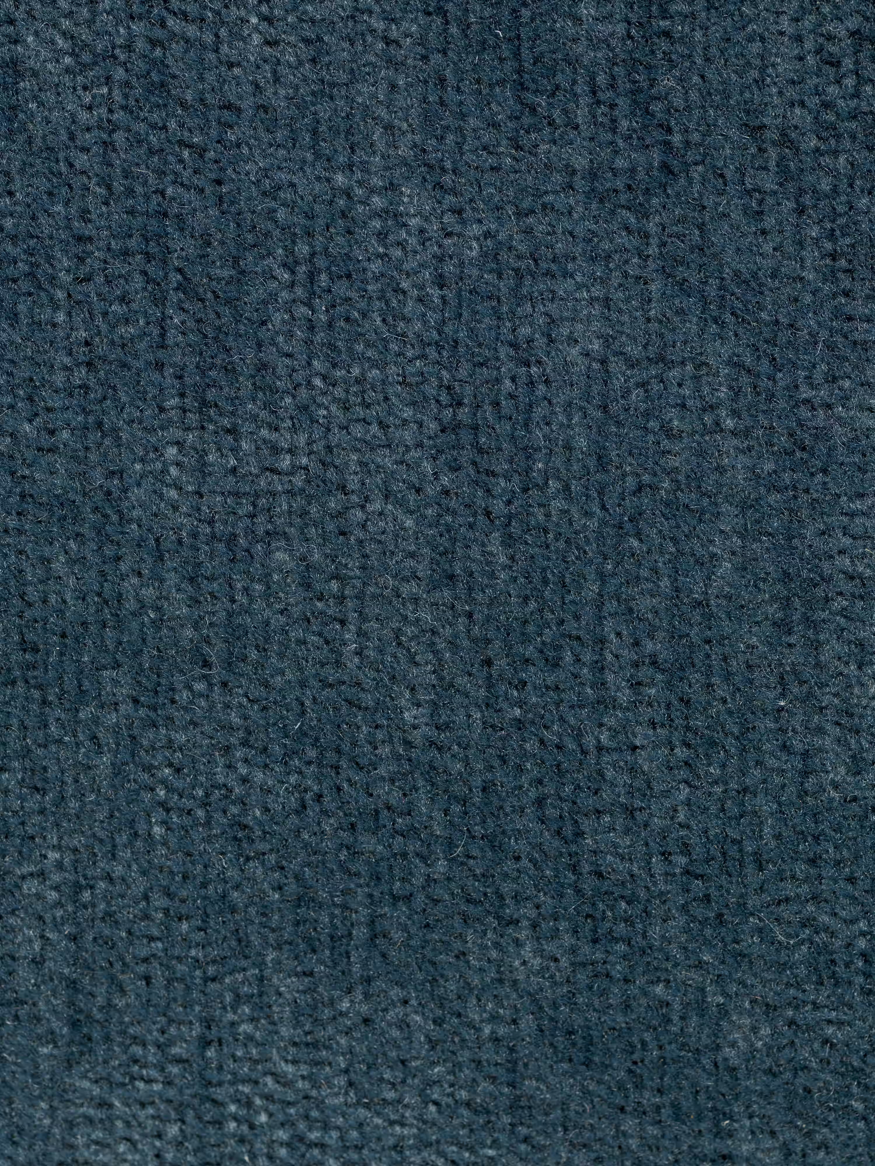 Primo piano della superficie di un tessuto grigio-blu scuro dalla trama ruvida del divano letto matrimoniale Rift a 2 e 3 posti con schienali mobili di Divani.Store, caratterizzato da un delicato motivo a griglia ottenuto dalla tessitura di fibre morbide e corte. L’illuminazione mette in risalto la trama del materiale e le delicate variazioni di colore, conferendogli un aspetto leggermente vellutato e omogeneo.