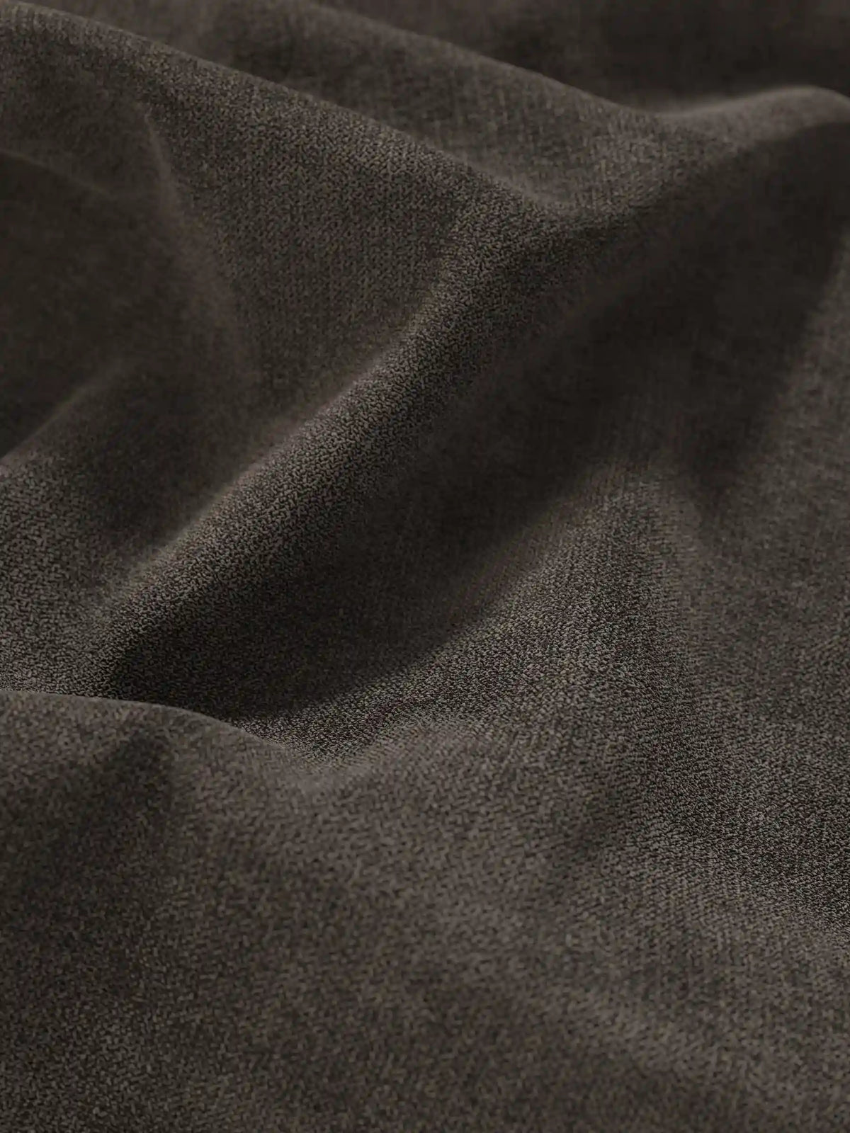 Primo piano del tessuto grigio antracite scuro su un letto sommier imbottito ERON con vano contenitore in tessuto impermeabile certificato Oeko-Tex, che mostra una trama fine e granulosa in morbide pieghe con sottili riflessi e ombre profonde.
