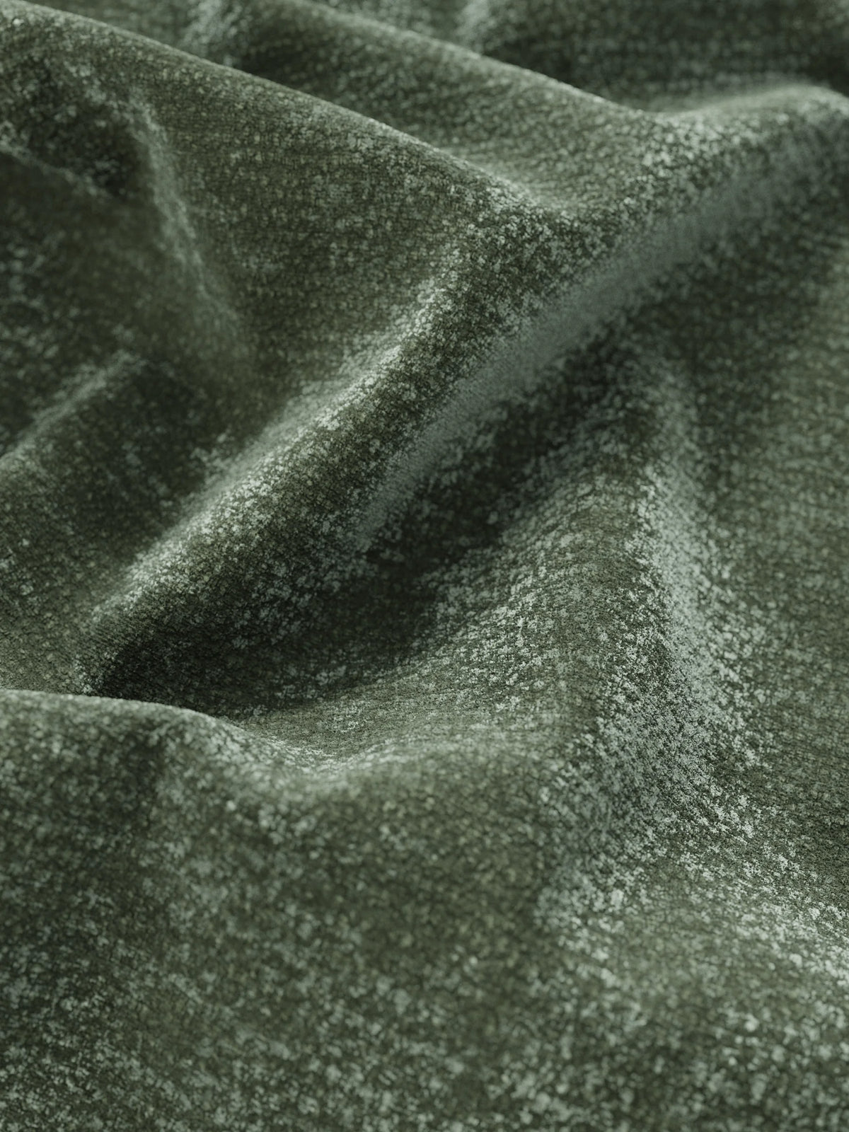 Primo piano sul tessuto color verde salvia dall’effetto vellutato della testiera verticale del letto imbottito ONYX con contenitore, realizzata in tessuto certificato Oeko-Tex®, caratterizzata da pieghe morbide e fluide che creano giochi di luci e ombre.