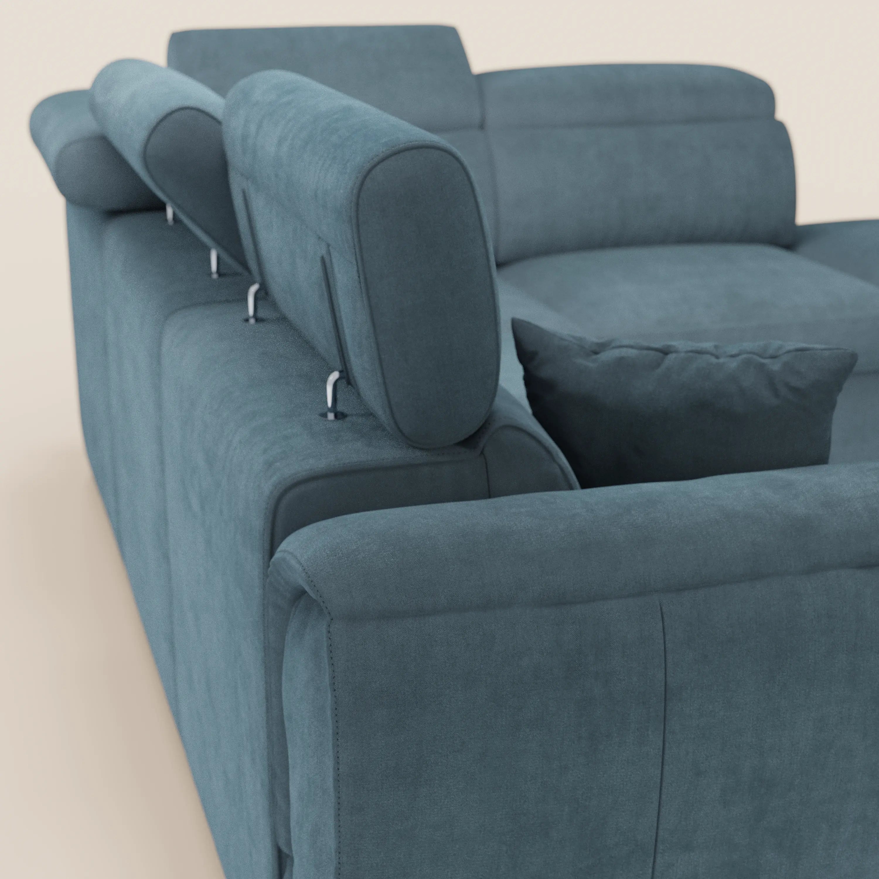 Un primo piano del divano angolare reversibile Titano di Divani.Store, rivestito in tessuto blu-verde acqua Oeko-Tex® antimacchia, con poggiatesta reclinabili, pouf contenitore abbinato e un design pulito e moderno su uno sfondo chiaro.
