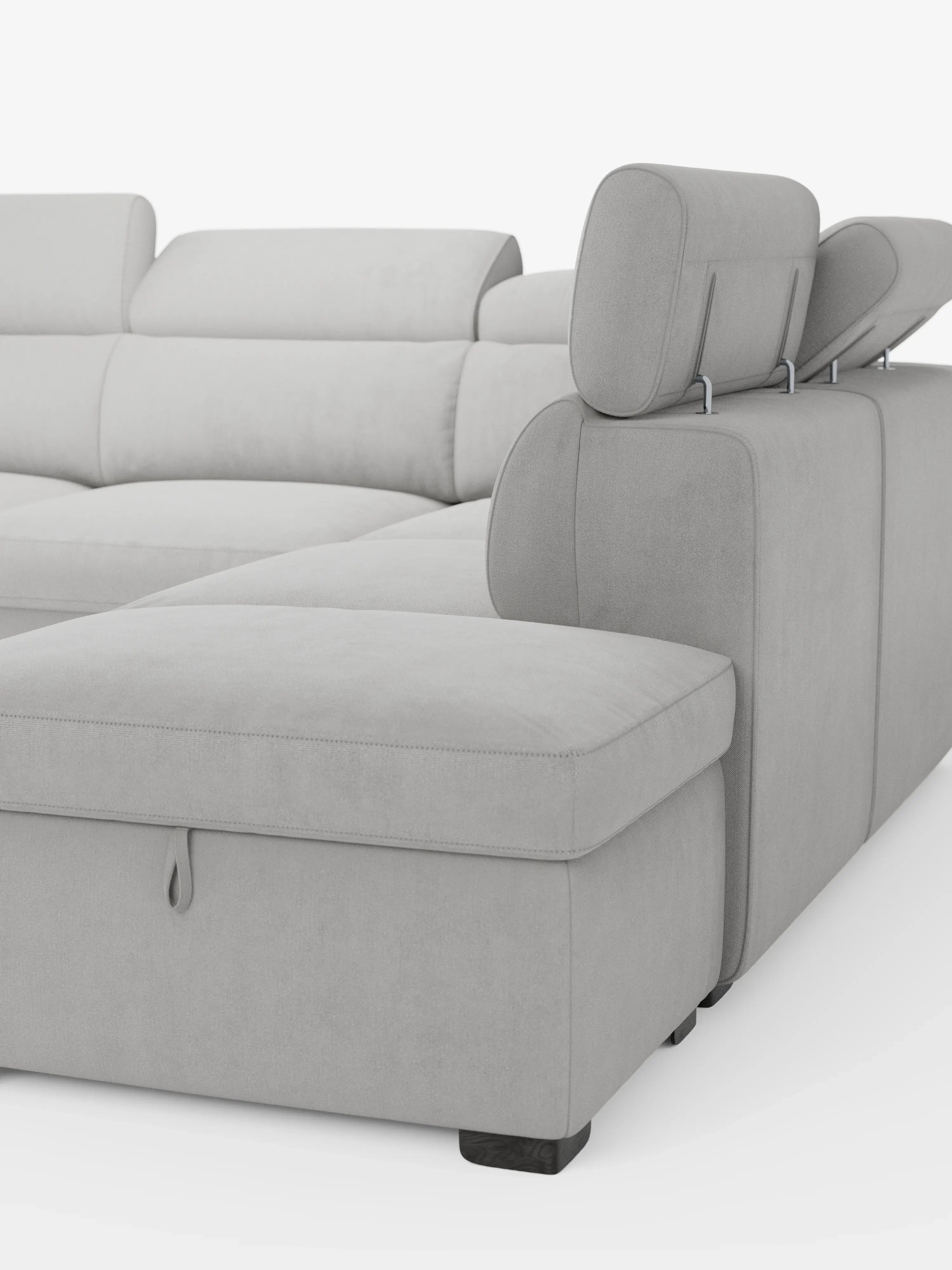 Un divano angolare reversibile Titano in stile contemporaneo di Divani.Store, rivestito in morbido tessuto grigio chiaro Oeko-Tex® antimacchia, dotato di poggiatesta regolabili e chaise longue. Il divano componibile presenta una linguetta a vista sulla parte anteriore della chaise longue che consente l’accesso a uno spazio contenitivo integrato ed è dotato di un pouf contenitore. Le linee pulite ne esaltano il design moderno, il tutto su uno sfondo bianco a tinta unita.