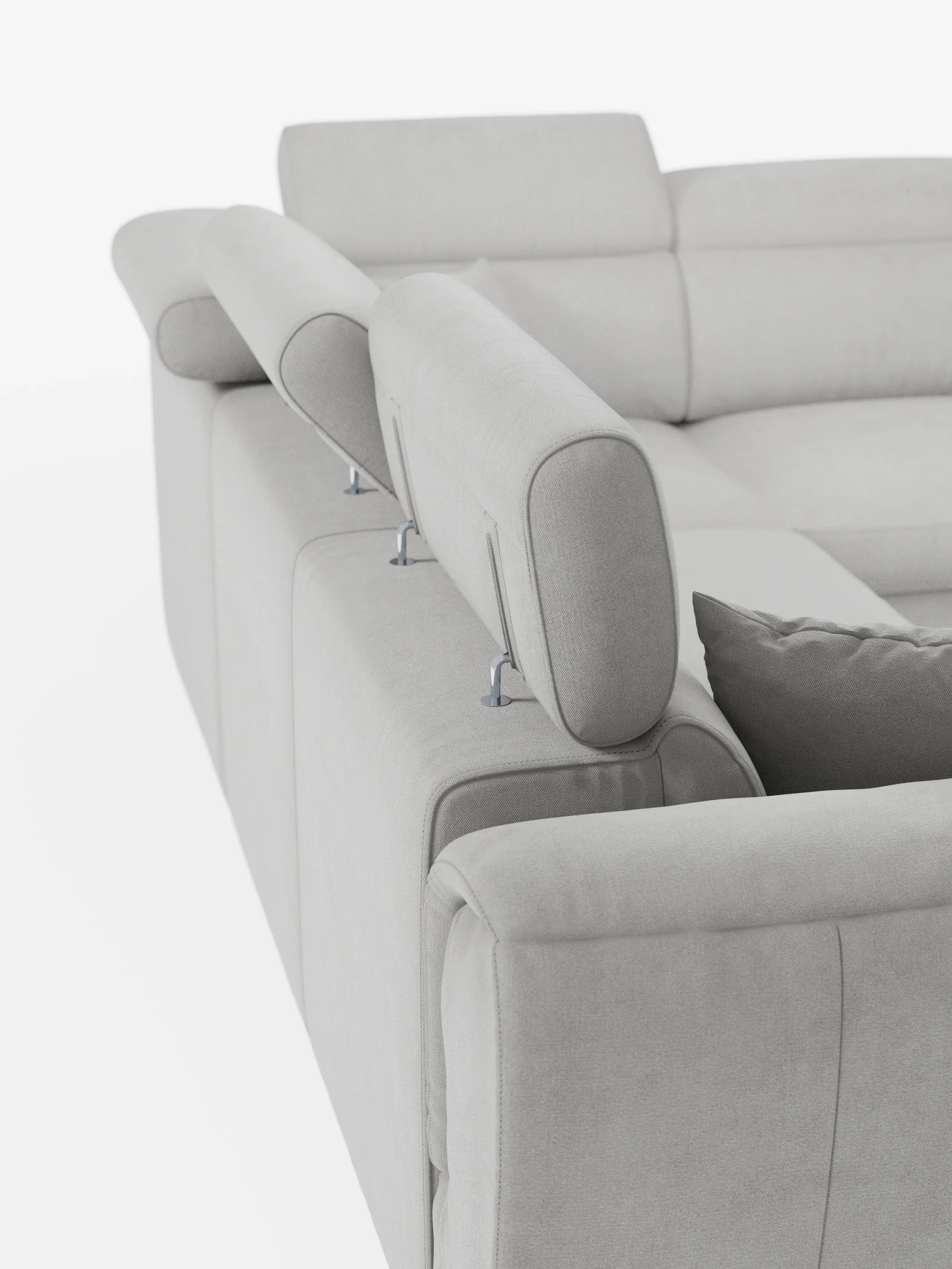 Un primo piano del divano angolare reversibile con letto estraibile e pouf contenitore "Titano" di Divani.Store, caratterizzato da un design moderno in grigio chiaro con poggiatesta reclinabili in tessuto Smacchiabile Oeko-Tex® e un cuscino coordinato. I poggiatesta sono sollevati, lasciando intravedere eleganti meccanismi di supporto in metallo, mentre il morbido tessuto risalta sullo sfondo bianco a tinta unita.
