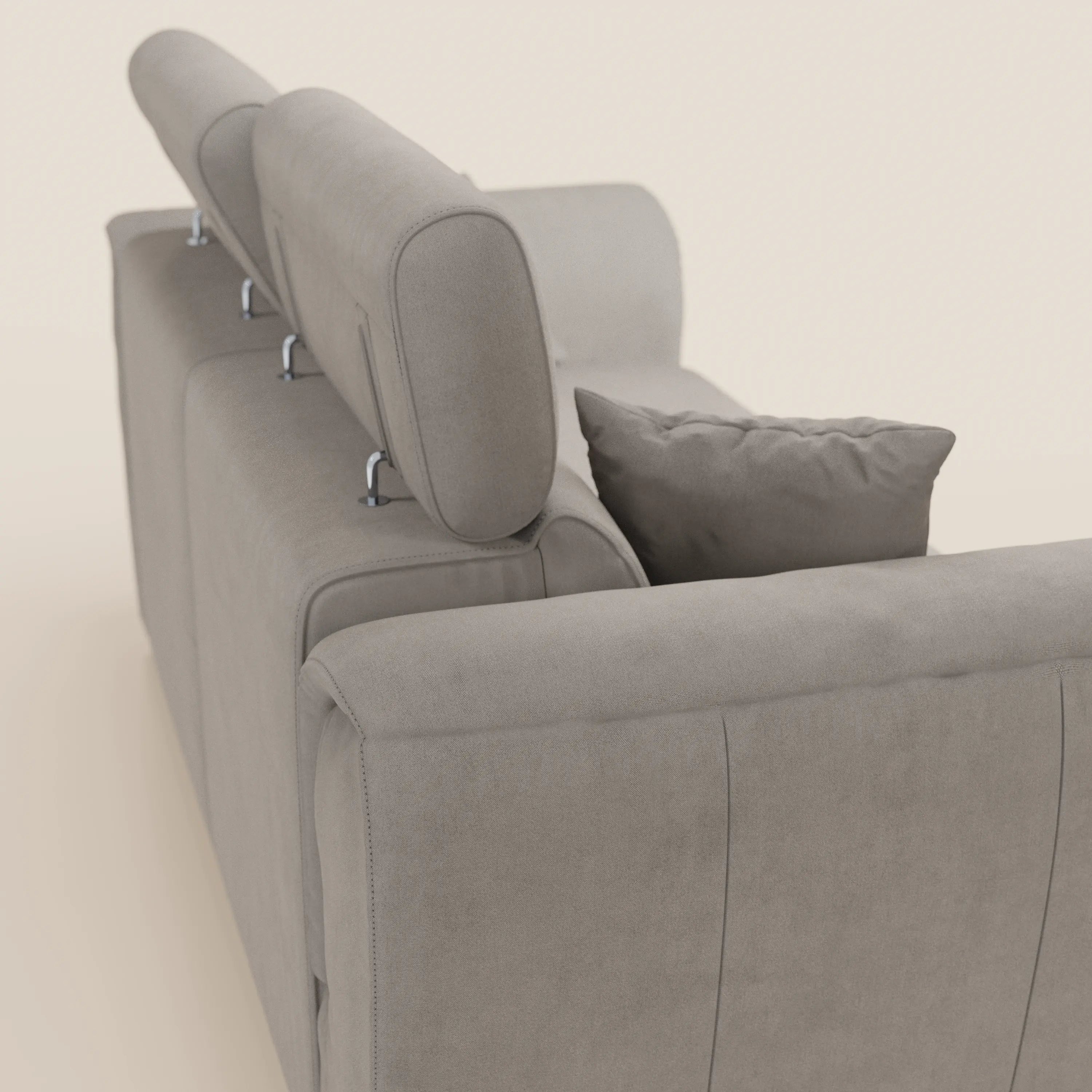 Il divano a due posti estraibile Titano di Divani.Store è raffigurato di retro, in un moderno tessuto grigio chiaro con tre poggiatesta regolabili e un cuscino rettangolare abbinato, su uno sfondo bianco sporco.