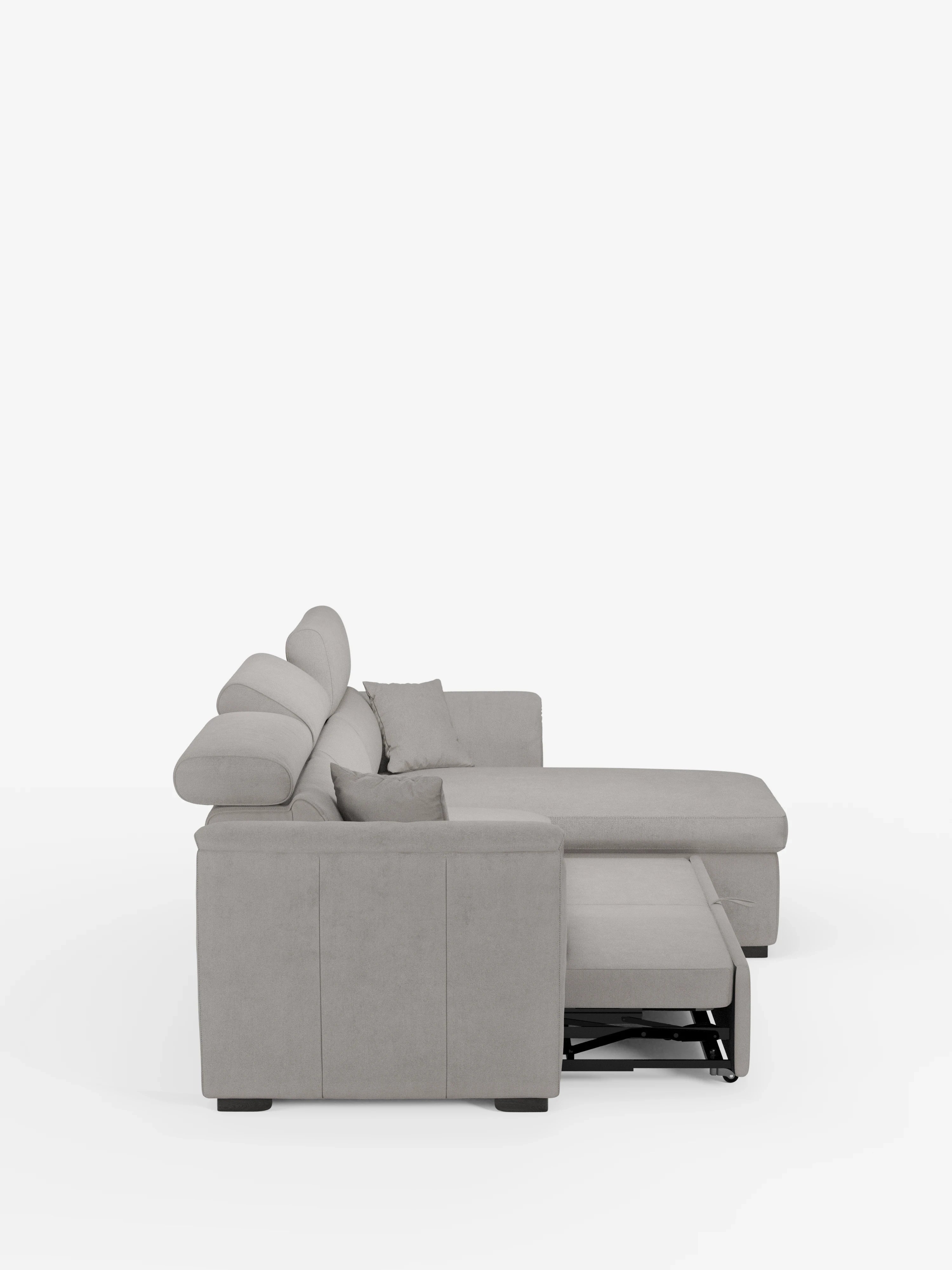 Il divano letto Titano con penisola reversibile e contenitore di Divani.Store è un moderno divano componibile a L di colore grigio chiaro, dotato di una chaise longue sulla destra, tre cuscini dello schienale e due piccoli cuscini decorativi disposti sulla chaise longue. L'elemento estraibile è parzialmente esteso e lo sfondo è bianco a tinta unita.