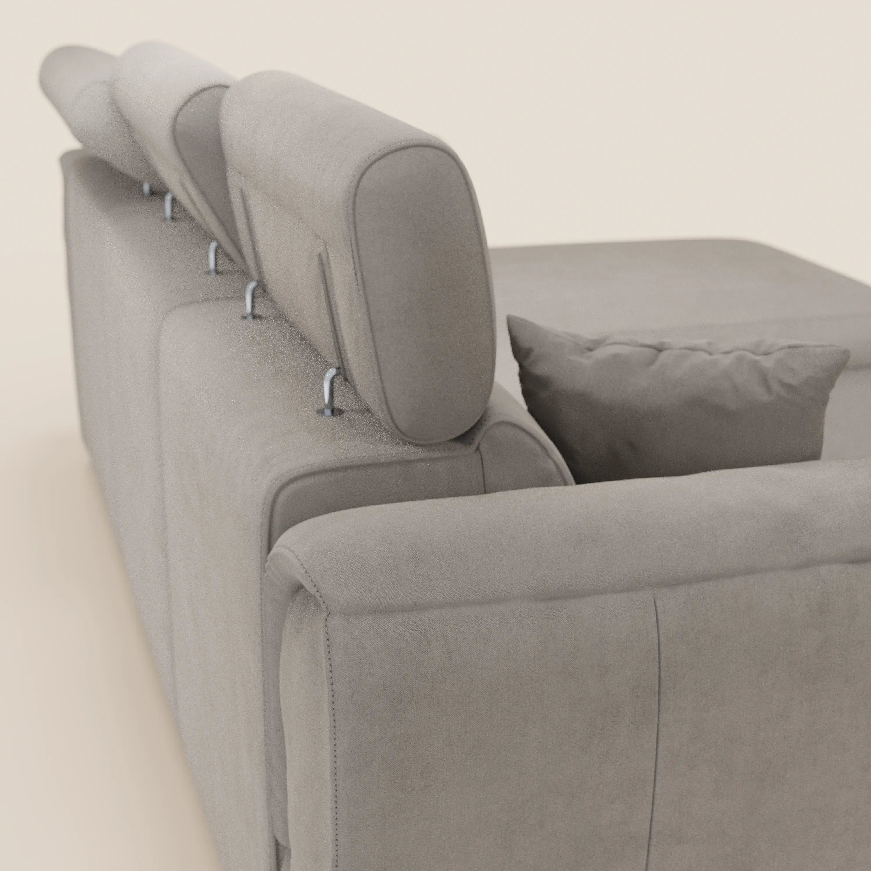 Il divano letto Titano con penisola reversibile di Divani.Store è dotato di poggiatesta reclinabili e di un elemento estraibile in tessuto smacchiabile, ripreso nella vista posteriore e laterale per un look moderno e minimalista su uno sfondo chiaro.