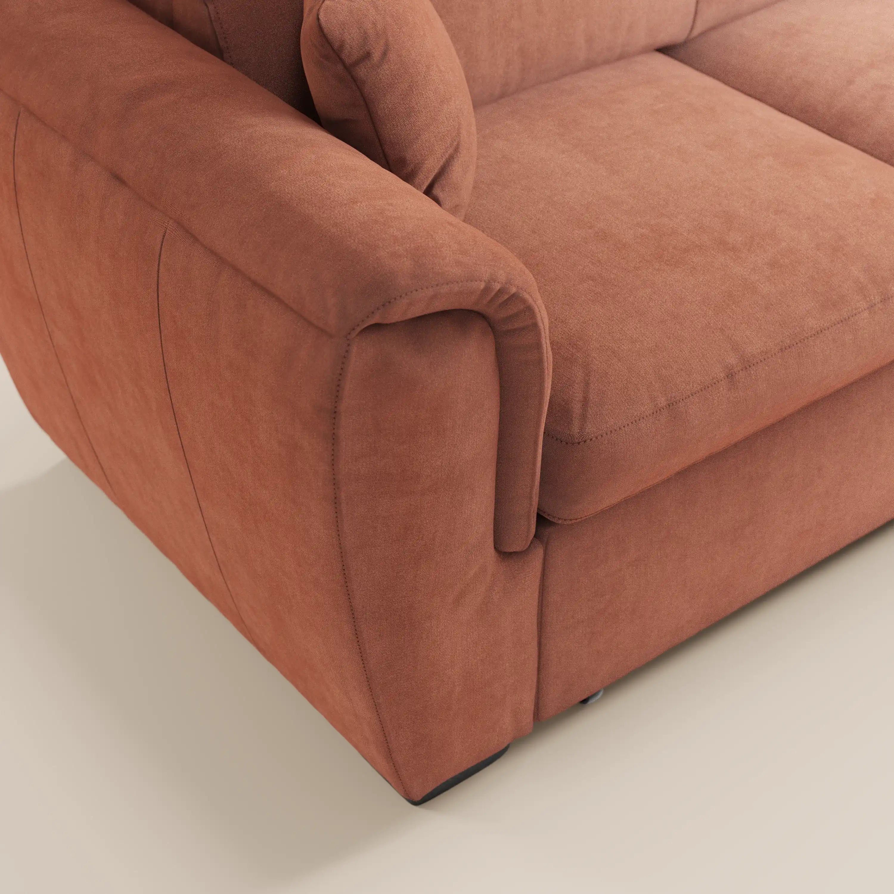 Primo piano del divano letto Titano di Divani.Store in color marrone-rossastro, caratterizzato da tessuto antimacchia, poggiatesta regolabili, una chaise longue reversibile con vano portaoggetti e un elemento estraibile; mette in risalto la morbida trama e il design imbottito su uno sfondo chiaro.