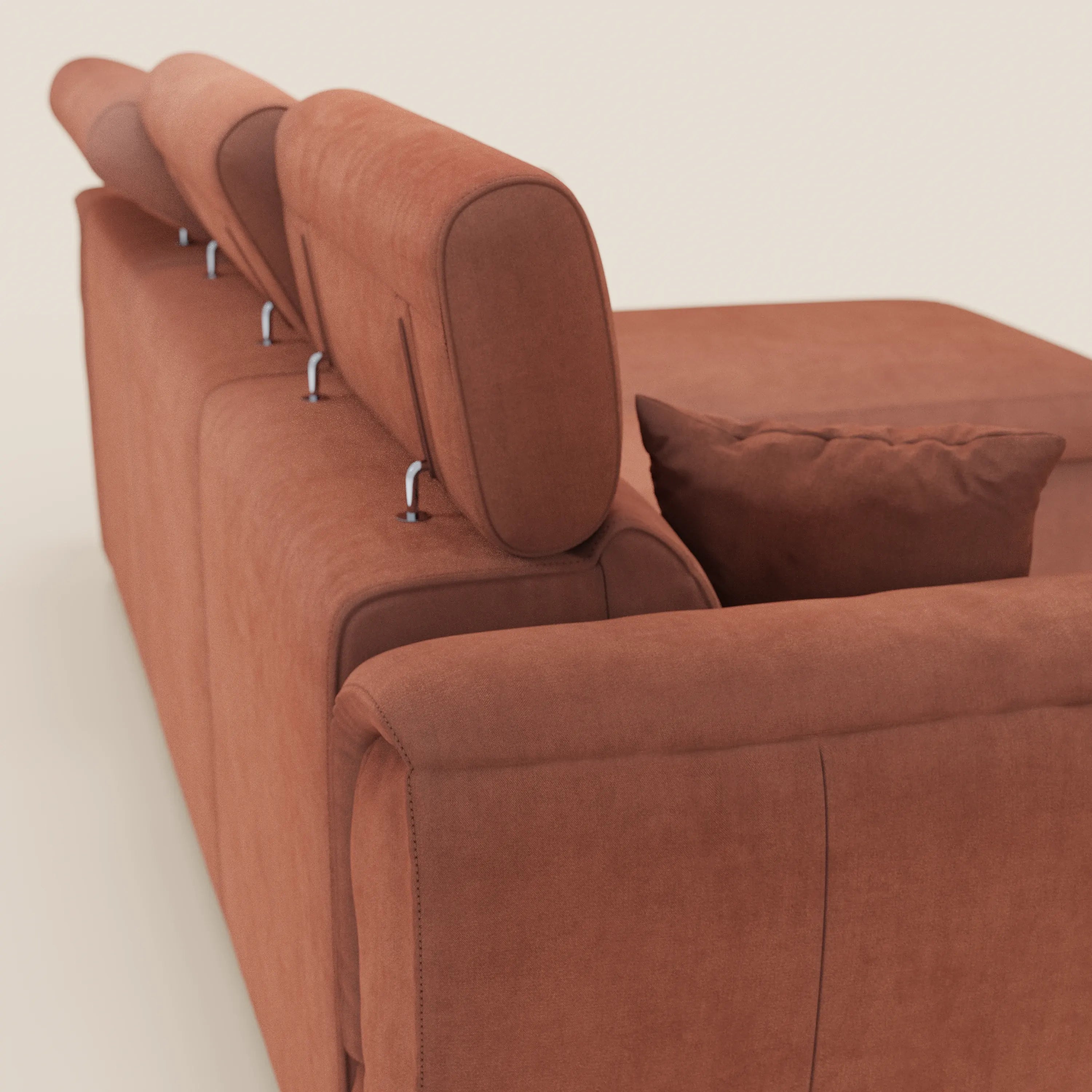 Un primo piano del divano letto Titano con penisola reversibile di Divani.Store, caratterizzato da tessuto smacchiabile, poggiatesta reclinabili, un elemento estraibile e una chaise longue con vano contenitore, in un moderno rivestimento marrone-rossastro su uno sfondo chiaro.