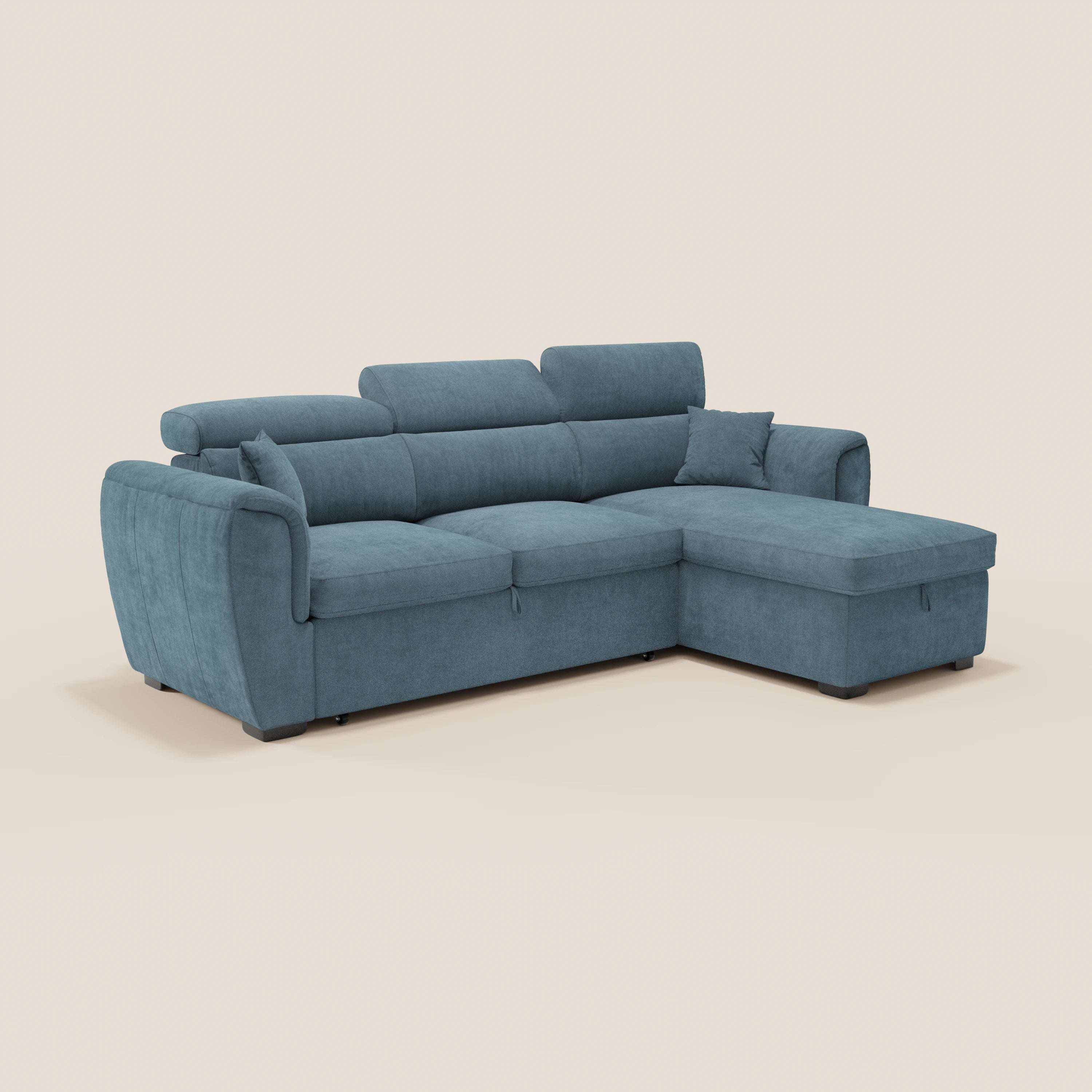 Il divano letto Titano di Divani.Store è dotato di una chaise longue reversibile con vano portaoggetti, poggiatesta reclinabili, letto estraibile, tessuto antimacchia e poggia su piedini neri corti su uno sfondo beige chiaro.