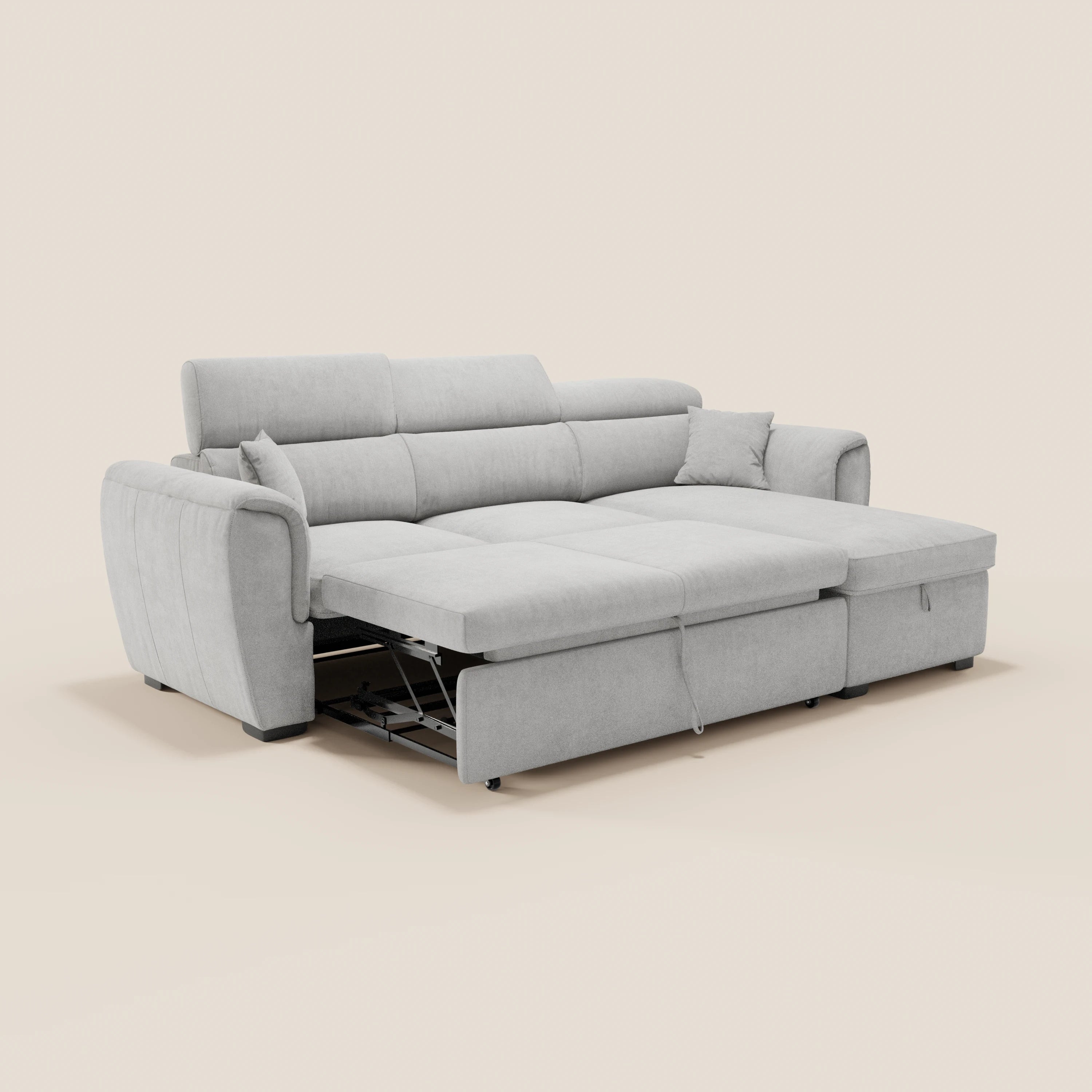 Il divano letto Titano di Divani.Store è raffigurato in grigio chiaro, con una chaise longue, due braccioli, morbidi cuscini, cuscini coordinati e un letto estraibile parzialmente aperto su uno sfondo beige.
