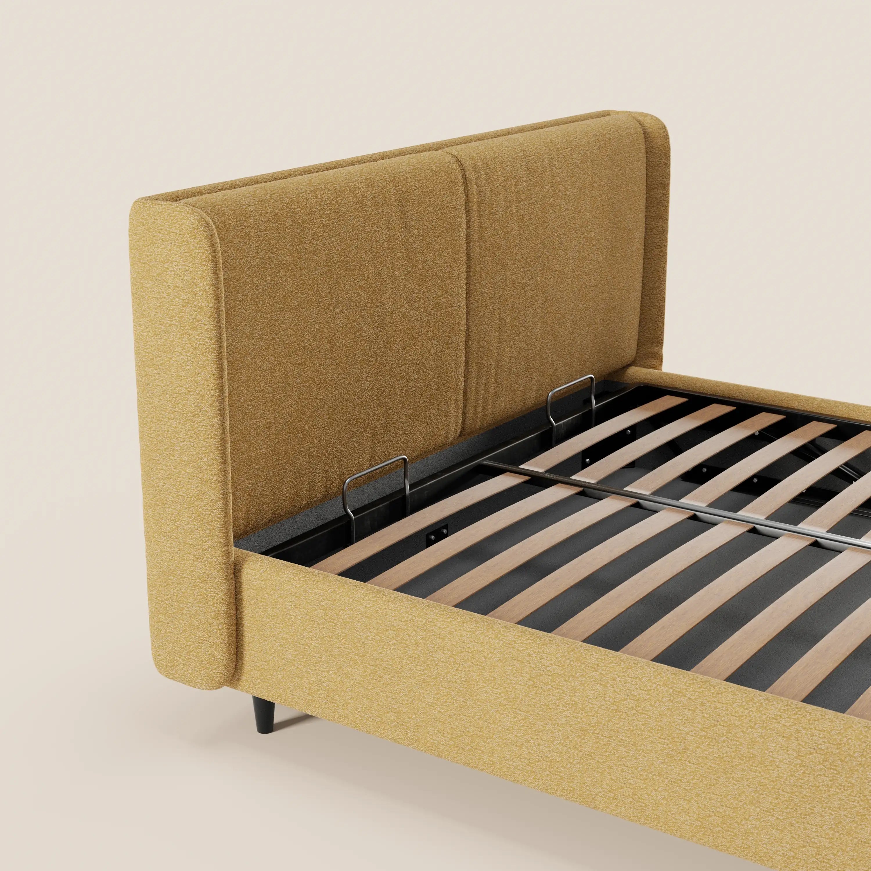 Una vista parziale del letto di design VALKIRIA di Letti.store in giallo senape, con testiera avvolgente, 2 cuscini imbottiti in tessuto Oeko-Tex®, doghe in legno e supporti in metallo nero: linee contemporanee e gambe corte nere.