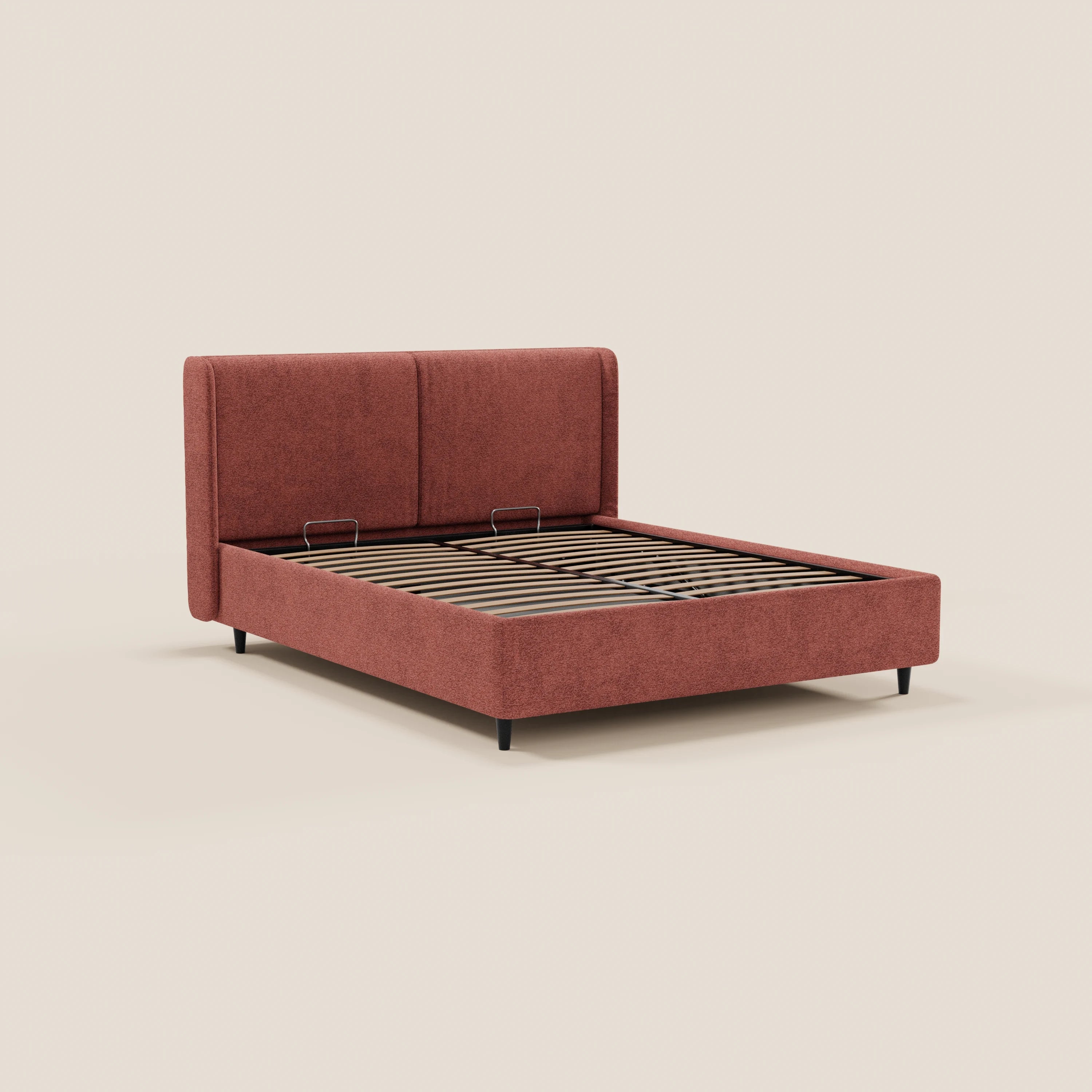 Il modello VALKIRIA di Letti.store è un letto di design dotato di spazio contenitivo, con una testiera avvolgente con 2 cuscini imbottiti e rivestito in tessuto Oeko-Tex® in una tonalità di rosso tenue. È caratterizzato da una rete a doghe in legno e da gambe corte nere, che risaltano su uno sfondo beige a tinta unita.