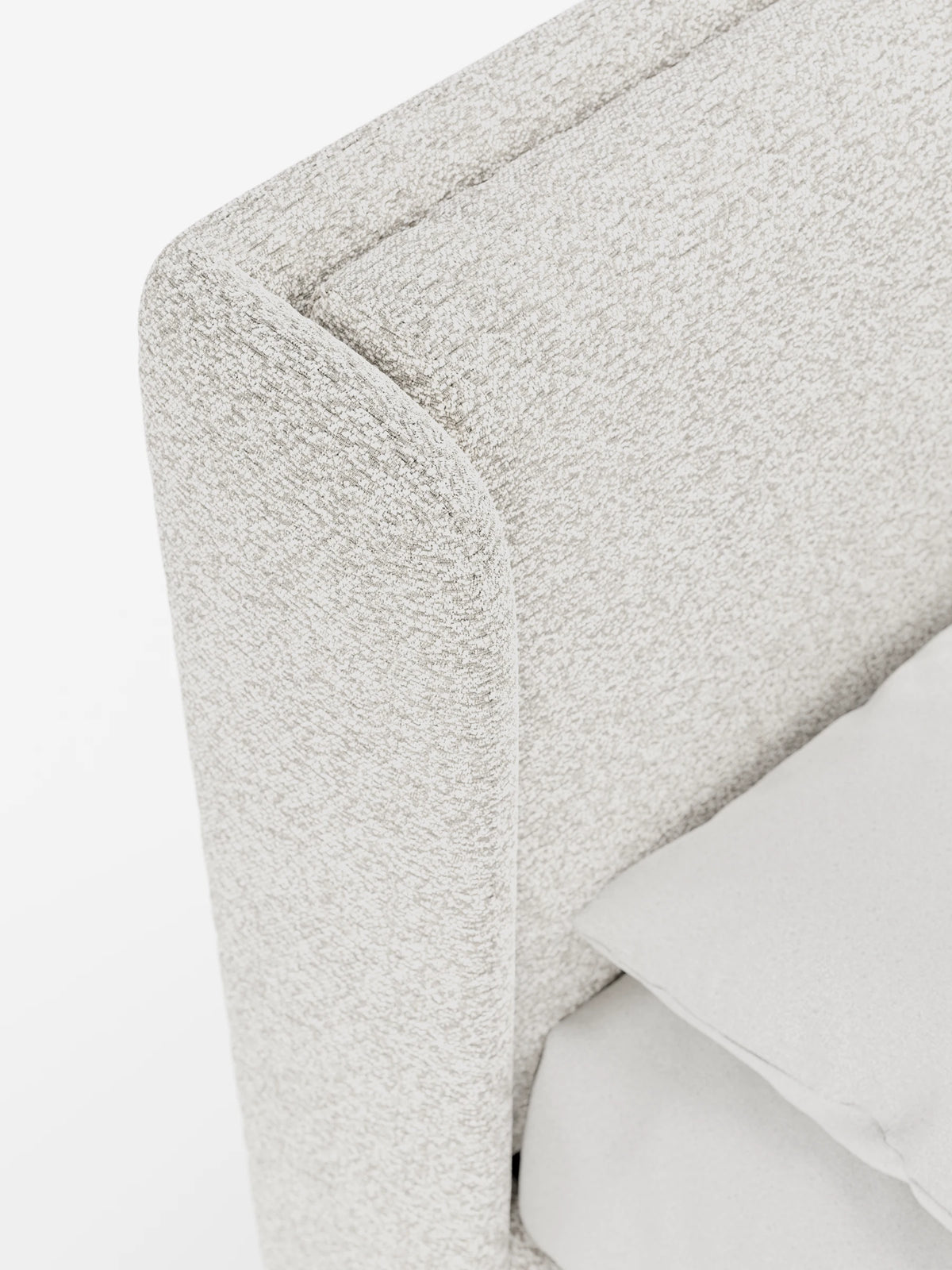 Un primo piano di un letto di design VALKIRIA con contenitore e testiera avvolgente, caratterizzata da un tessuto testato, di colore beige chiaro, e da un cuscino coordinato, su uno sfondo bianco uniforme.