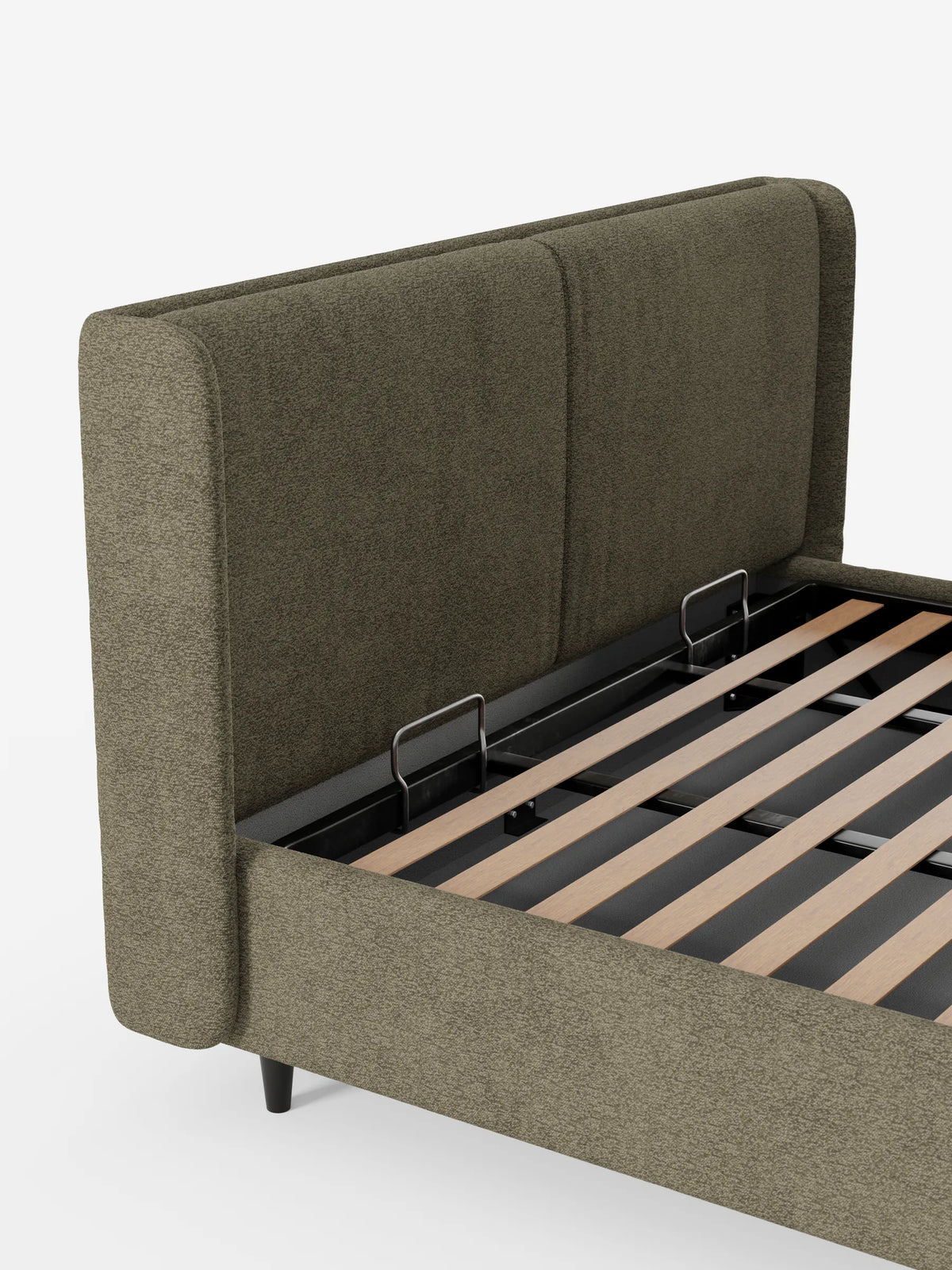 Il letto di design VALKIRIA con contenitore e testiera avvolgente è un letto imbottito di colore verde oliva con una testiera alta e avvolgente; la base aperta del contenitore lascia intravedere le doghe in legno sostenute da una struttura in metallo nero.