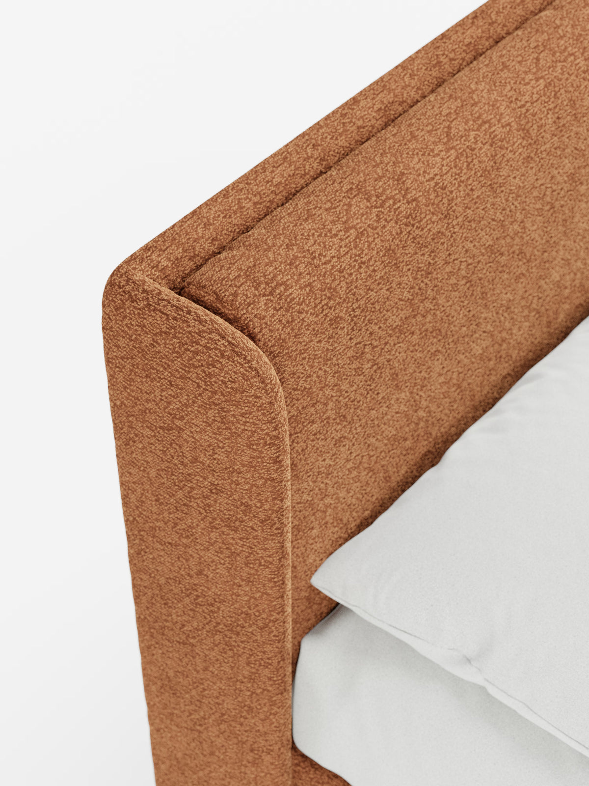 Primo piano del letto di design VALKIRIA con contenitore e testiera avvolgente di Letti.store, caratterizzato da una testiera e da un pannello laterale in tessuto Oeko-Tex® color ruggine e dalla trama ruvida, con due cuscini imbottiti. Sul materasso giacciono un cuscino e un lenzuolo bianchi, il tutto su uno sfondo bianco. È visibile solo l’angolo superiore del letto, a sottolineare il suo design contemporaneo.