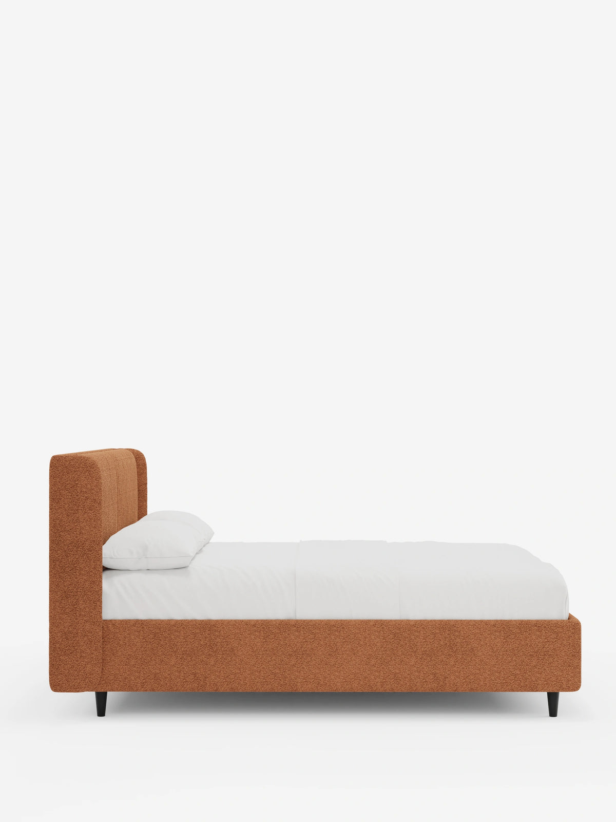 Una vista laterale del letto di design VALKIRIA con contenitore e testiera avvolgente, rivestito in tessuto color ruggine, con una testiera alta e avvolgente, biancheria da letto bianca e sottili gambe affusolate nere su uno sfondo bianco.