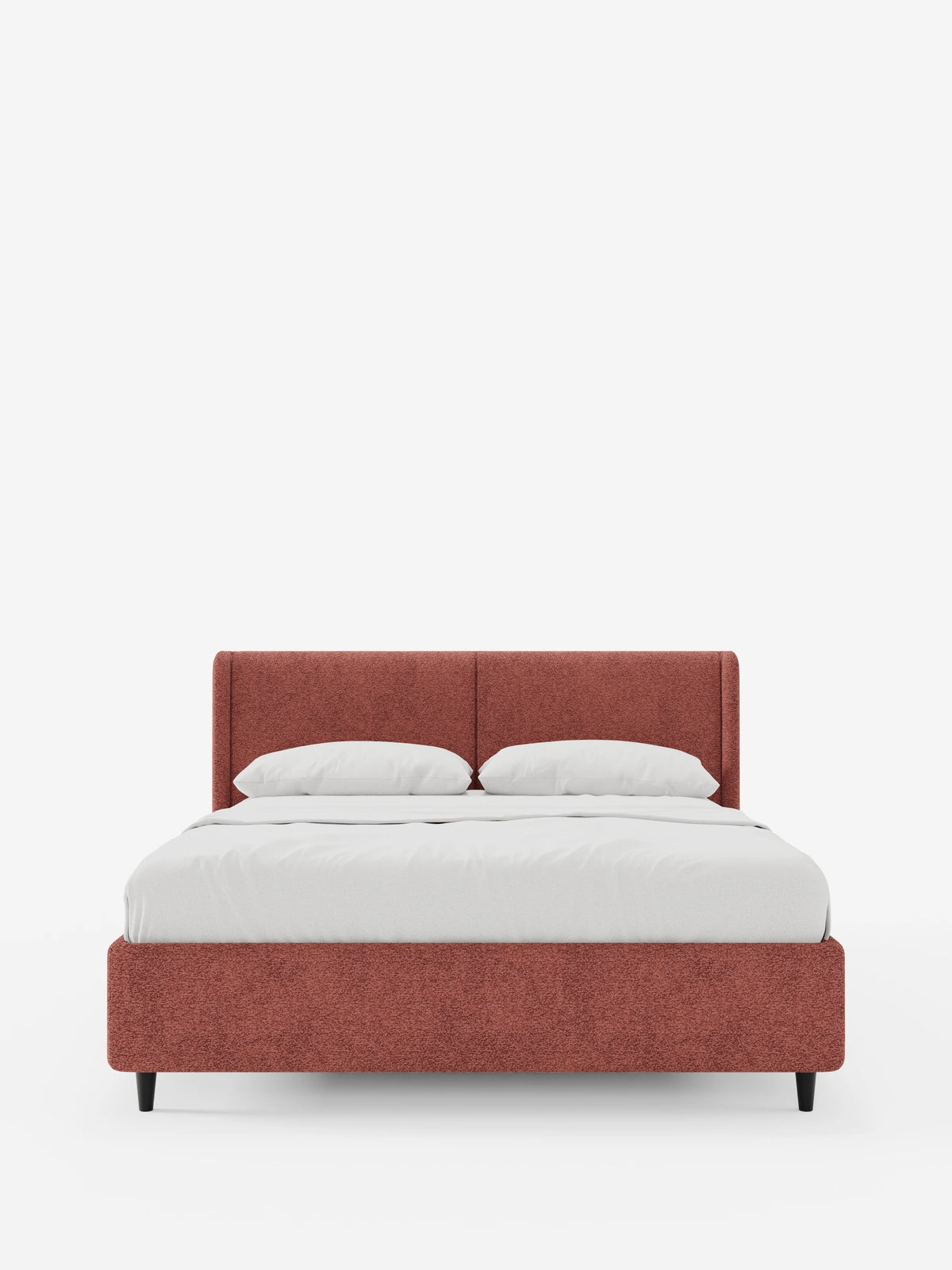 VALKIRIA, letto di design con contenitore e testiera avvolgente in tessuto color terracotta, dotato di due cuscini e biancheria da letto bianca, poggiante su quattro sottili gambe scure, in primo piano su uno sfondo bianco.