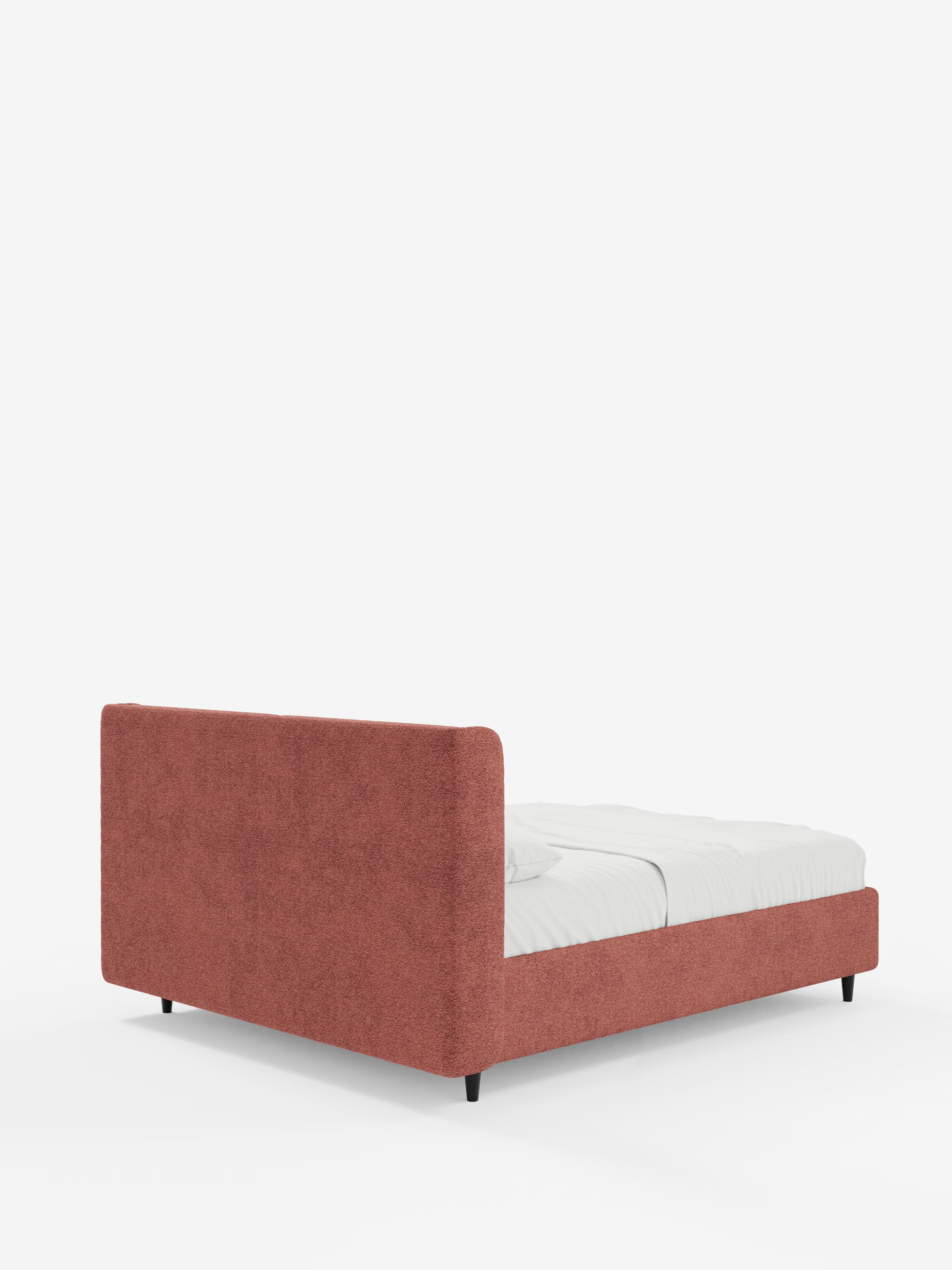 Un letto di design contemporaneo VALKIRIA di Letti.store, caratterizzato da una struttura imbottita bassa e rettangolare e da una testiera avvolgente con due cuscini imbottiti in tessuto rosso tenue certificato Oeko-Tex®. Sostenuto da corte gambe nere e rivestito con biancheria da letto di un bianco brillante, questo letto con contenitore è un esempio di eleganza moderna. Lo sfondo bianco a tinta unita esalta l’estetica minimalista e pulita dell’ambiente.