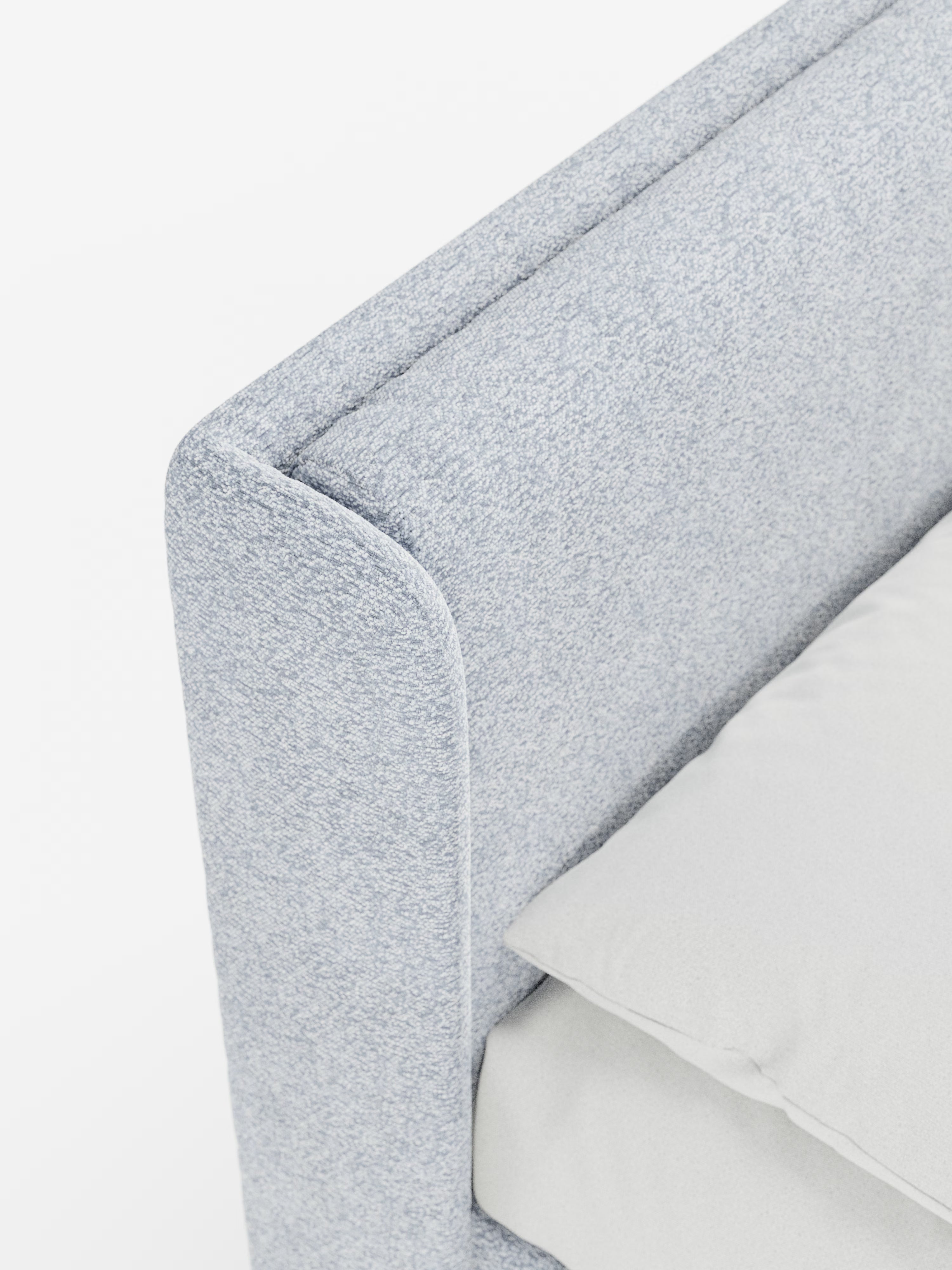 Primo piano del letto di design VALKIRIA di Letti.store in grigio chiaro, caratterizzato dalla sua distintiva testiera avvolgente imbottita con due morbidi cuscini in tessuto Oeko-Tex®. La biancheria da letto candida e un cuscino soffice poggiano contro la testiera dal rivestimento morbido. Un'illuminazione brillante e pulita mette in risalto la base contenitore integrata nel letto e il suo design minimalista e contemporaneo.