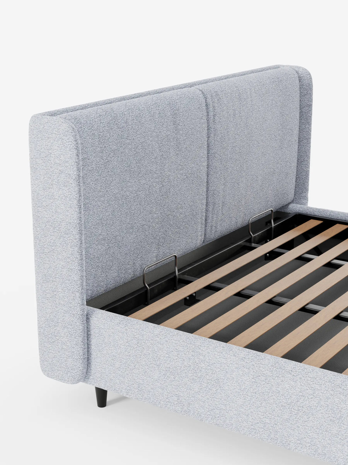 Il letto VALKIRIA presenta una testiera avvolgente imbottita di colore grigio chiaro con due pannelli verticali, montata su una struttura in stile contemporaneo con doghe in legno a vista e gambe corte e scure.