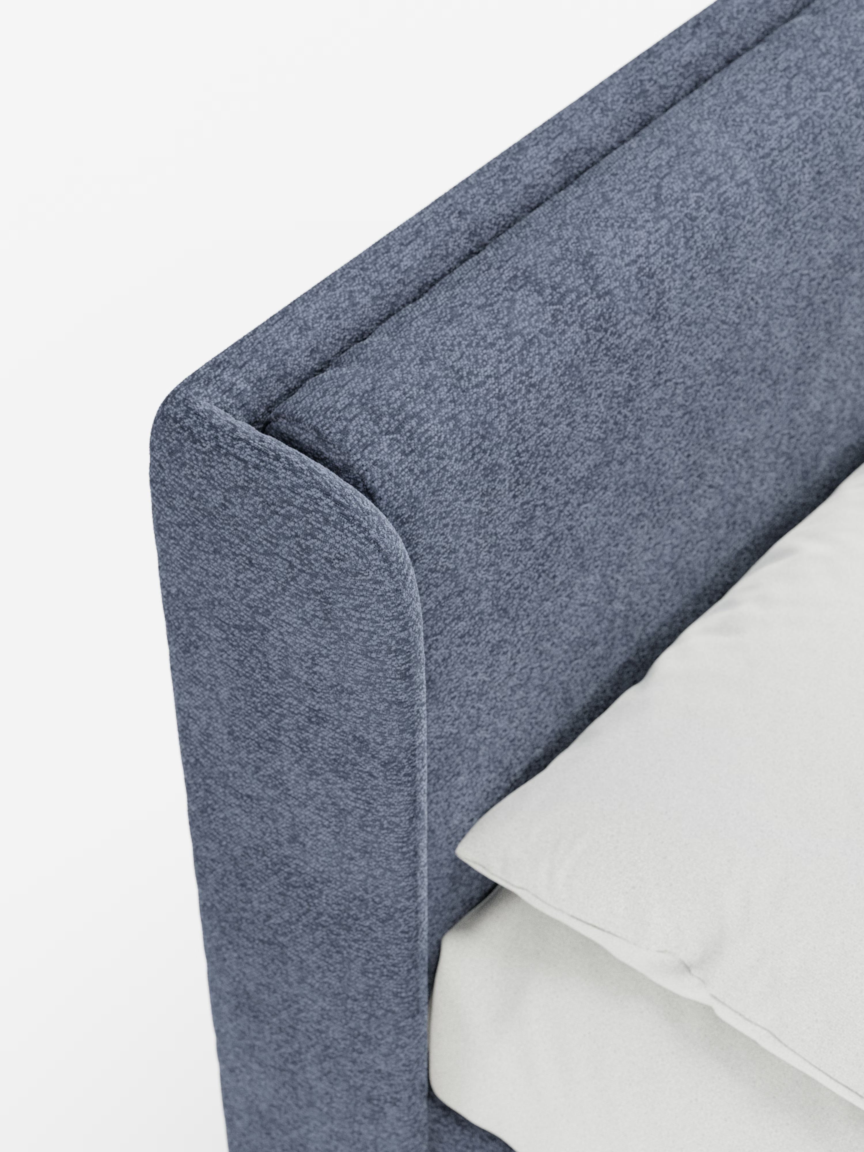 Primo piano del letto di design VALKIRIA con contenitore e testiera avvolgente di Letti.store, caratterizzato da una struttura imbottita di colore blu in morbido tessuto testurizzato certificato Oeko-Tex®. Due morbidi cuscini poggiano sul materasso, mentre le linee pulite e moderne del letto riflettono un design contemporaneo. Su uno sfondo bianco a tinta unita, l’immagine mette in risalto l’aspetto elegante e il colore sofisticato del letto imbottito.