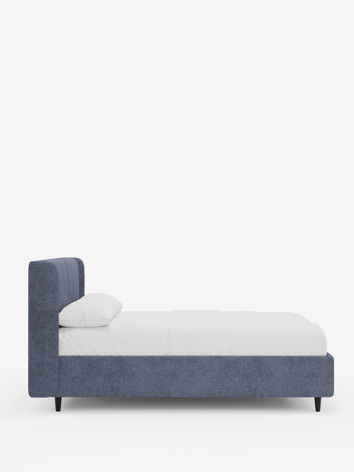 Una vista laterale del letto di design VALKIRIA con contenitore e testiera avvolgente, caratterizzato da una struttura in tessuto blu testurizzato, un'alta testiera avvolgente, biancheria da letto bianca, due morbidi cuscini e gambe corte e affusolate di colore nero.