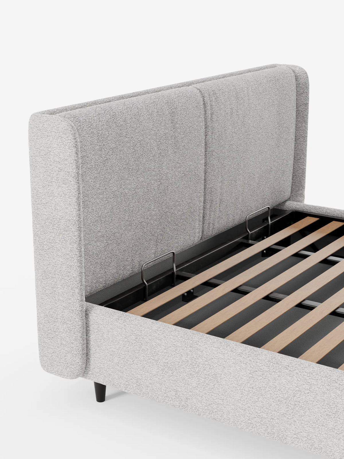 VALKIRIA, letto di design con contenitore e testiera avvolgente, è una struttura imbottita di colore grigio chiaro, caratterizzata da una testiera alta e ricurva, due cuscini integrati e gambe sottili e scure su uno sfondo bianco.