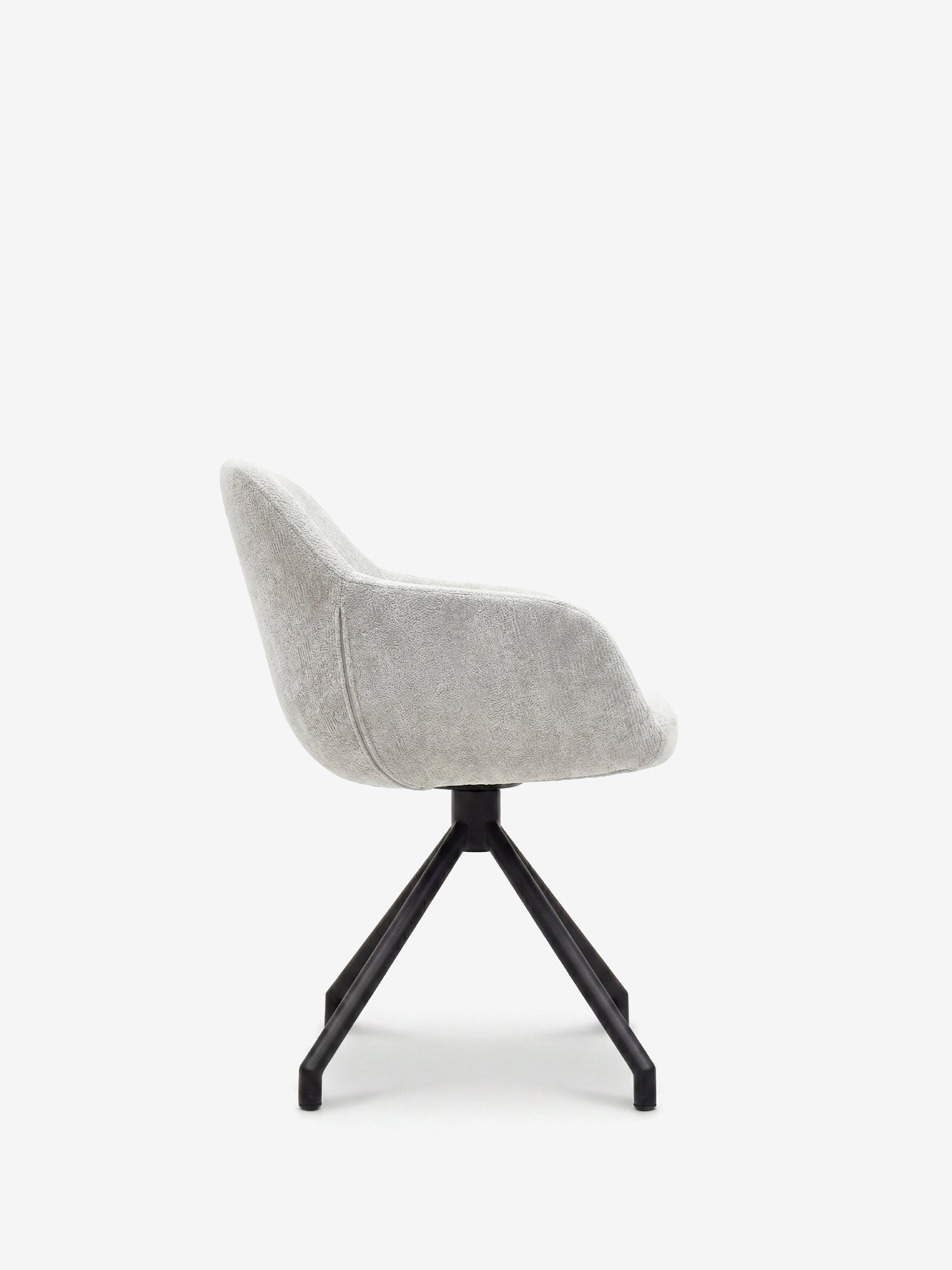 Sedia imbottita Vico di Divani.Store in morbido tessuto soft-touch OEKO-TEX® color grigio chiaro, con schienale e seduta curvati, base a quattro gambe in metallo nero inclinate verso l’esterno. Vista laterale su sfondo bianco.