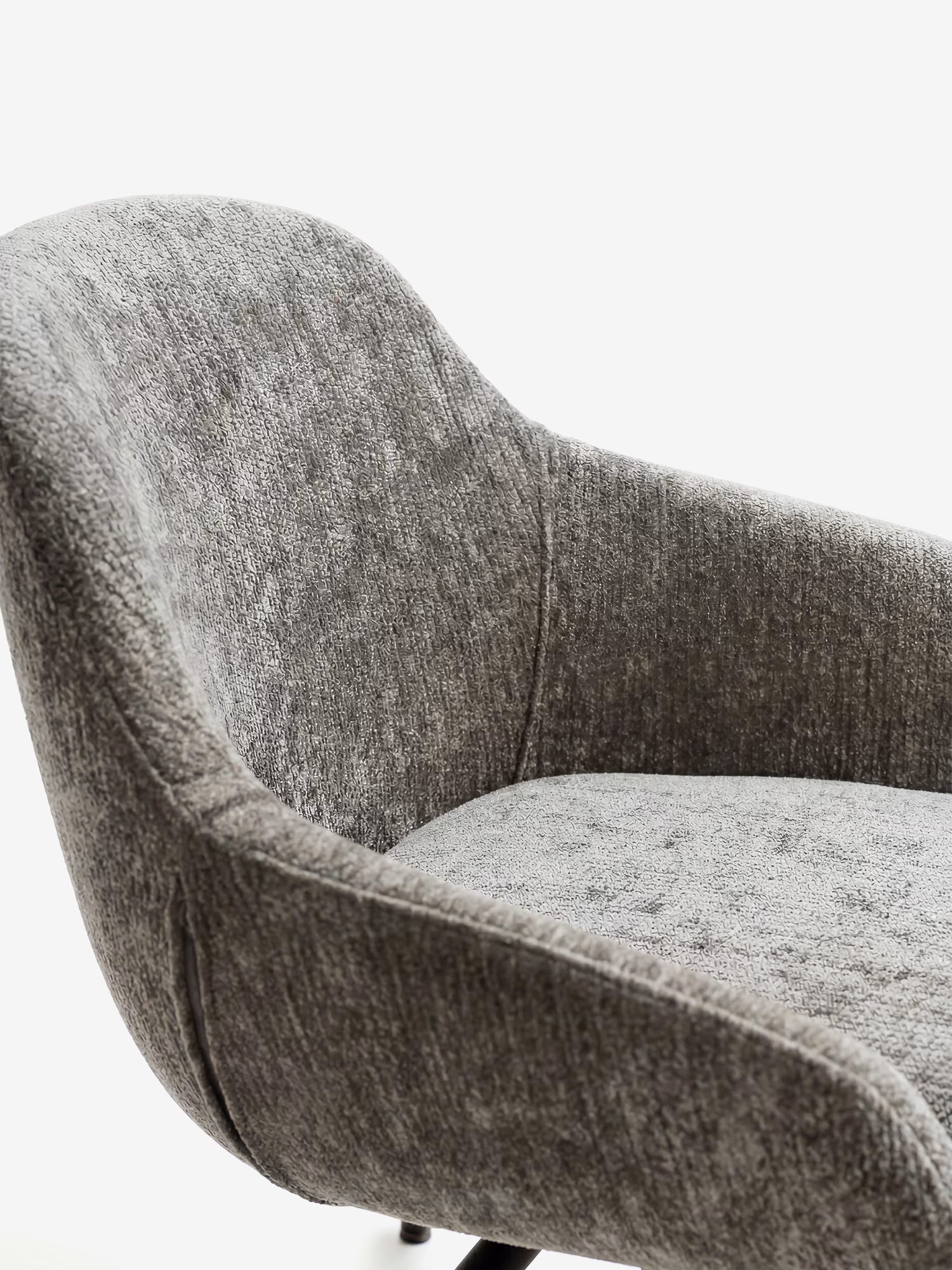 Un primo piano della sedia imbottita Vico di Divani.Store, realizzata con morbido tessuto soft-touch OEKO-TEX® in grigio testurizzato e gambe in metallo nero, con schienale curvo e imbottitura soffice su uno sfondo bianco a tinta unita.