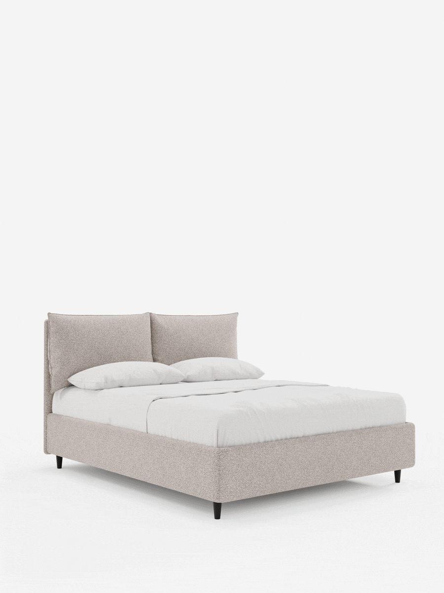 Il letto imbottito ZAYRON con contenitore e morbidi cuscini regolabili presenta una struttura in tessuto beige chiaro a trama, due cuscini regolabili e biancheria da letto bianca, il tutto su gambe affusolate scure su uno sfondo bianco.