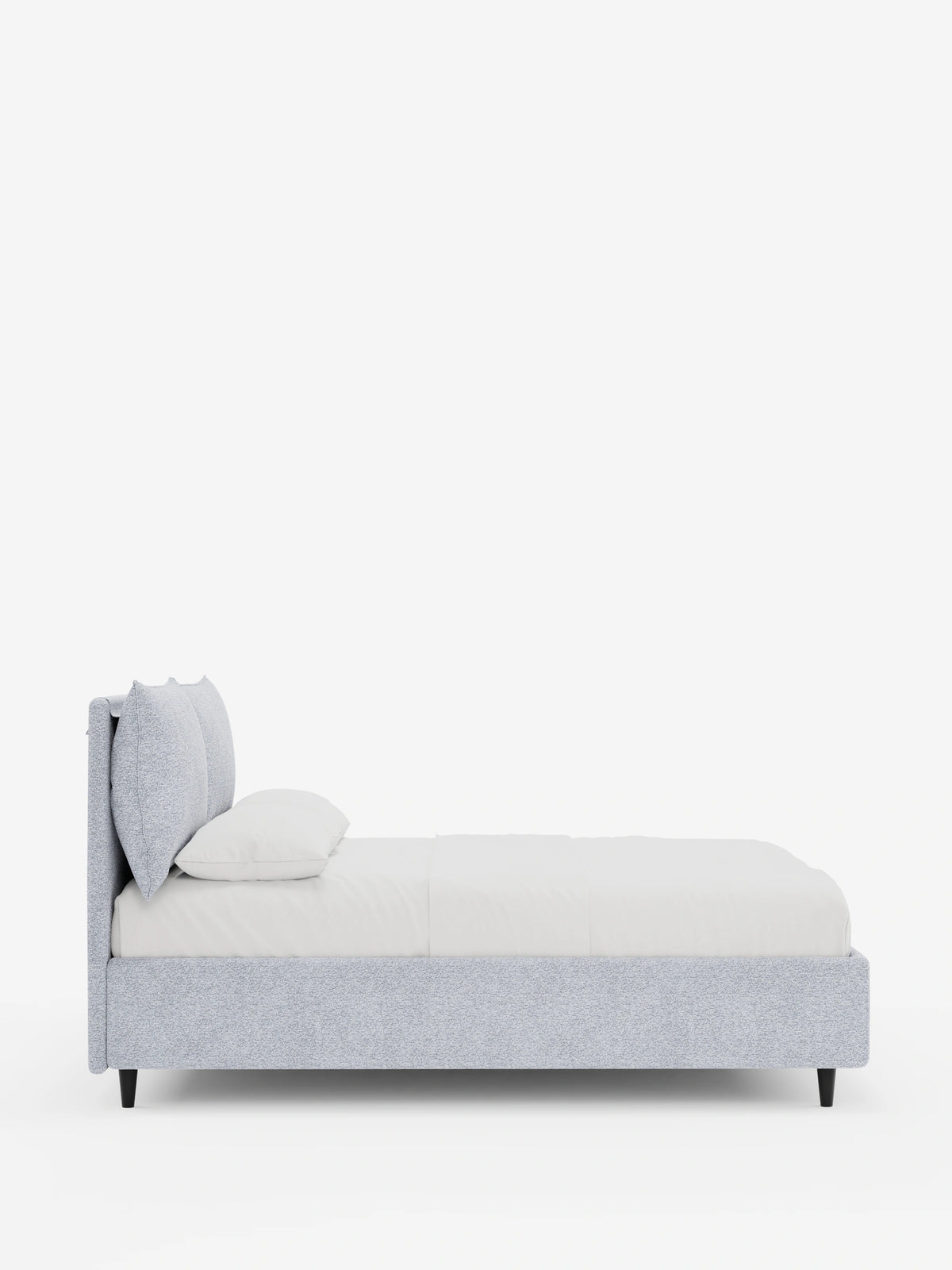 Un moderno letto imbottito ZAYRON grigio chiaro con contenitore e morbidi cuscini regolabili, visto di profilo, caratterizzato da una testiera spessa e regolabile con due cuscini, una struttura bassa su gambe nere e biancheria da letto bianca su sfondo bianco.