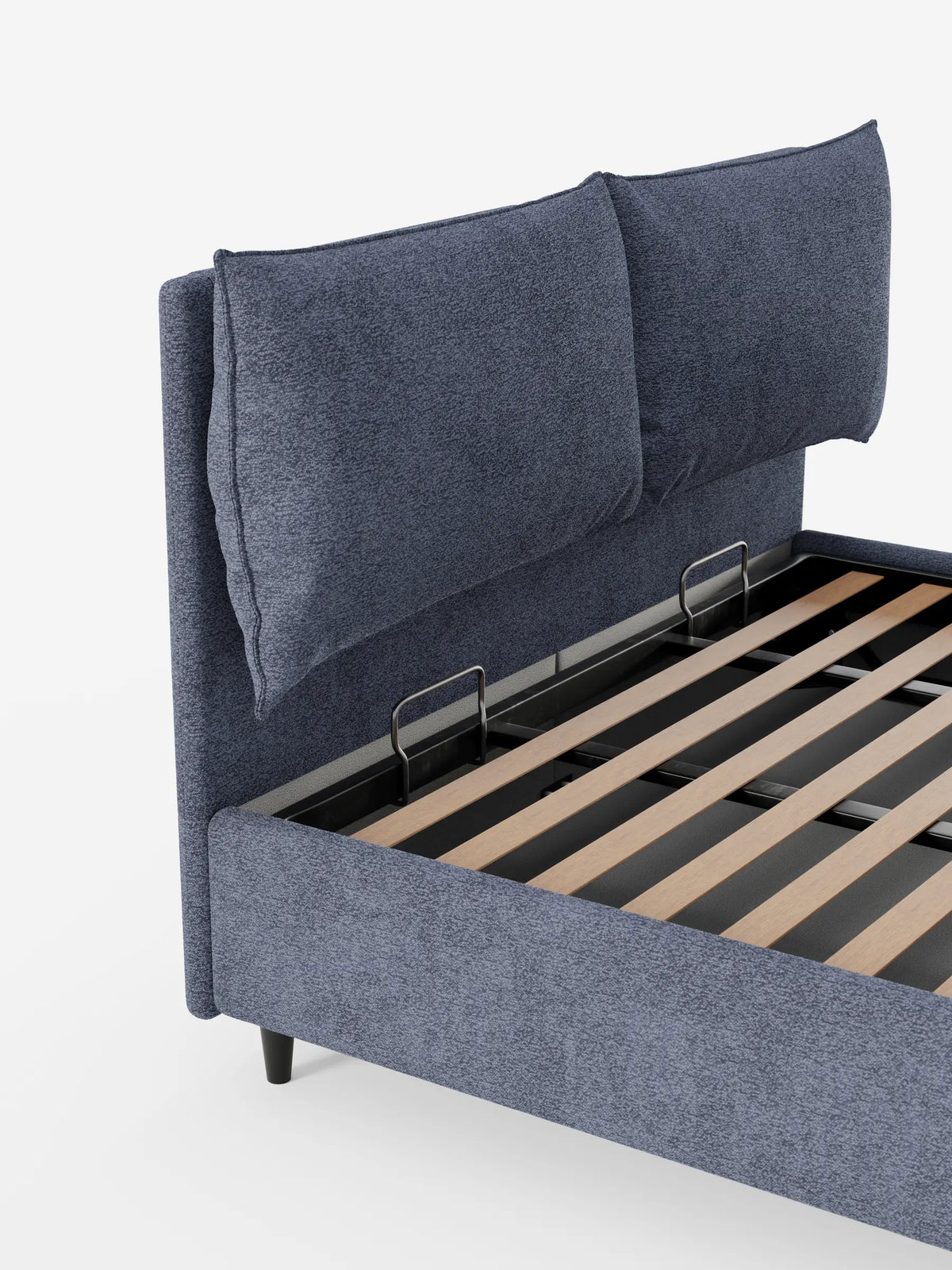 Un moderno letto imbottito ZAYRON blu scuro con contenitore e morbidi cuscini regolabili presenta due grandi cuscini regolabili sulla testiera e una base a doghe in legno parzialmente a vista, sostenuta da gambe corte e scure, su uno sfondo bianco.