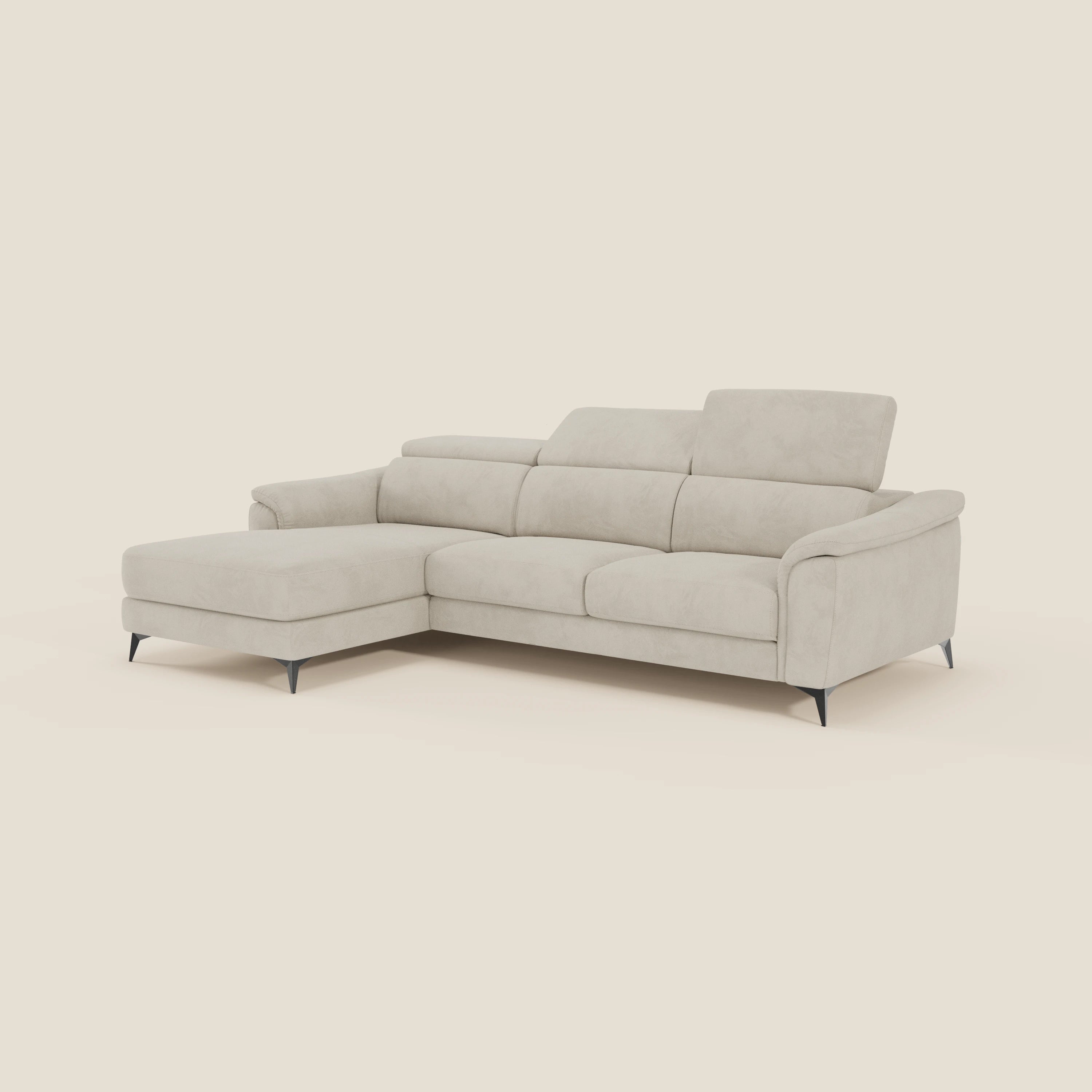 Arcos Divano con penisola di Divani.Store è caratterizzato da gambe alte, poggiatesta regolabili e rivestimento in microfibra impermeabile T11 panna: un elegante divano a L di produzione italiana su un semplice sfondo crema.